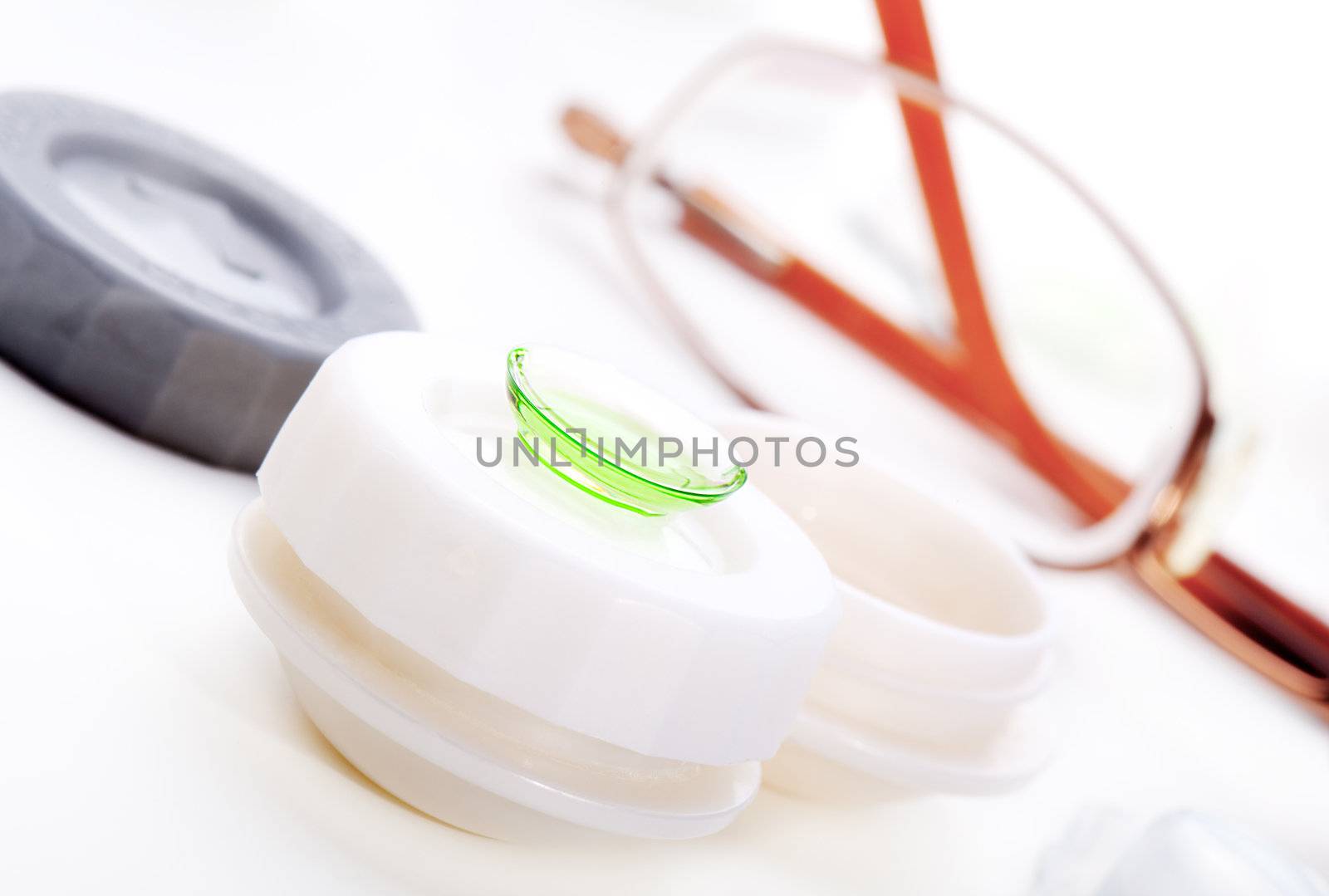 Close-up of green contact lenses in container with solution.