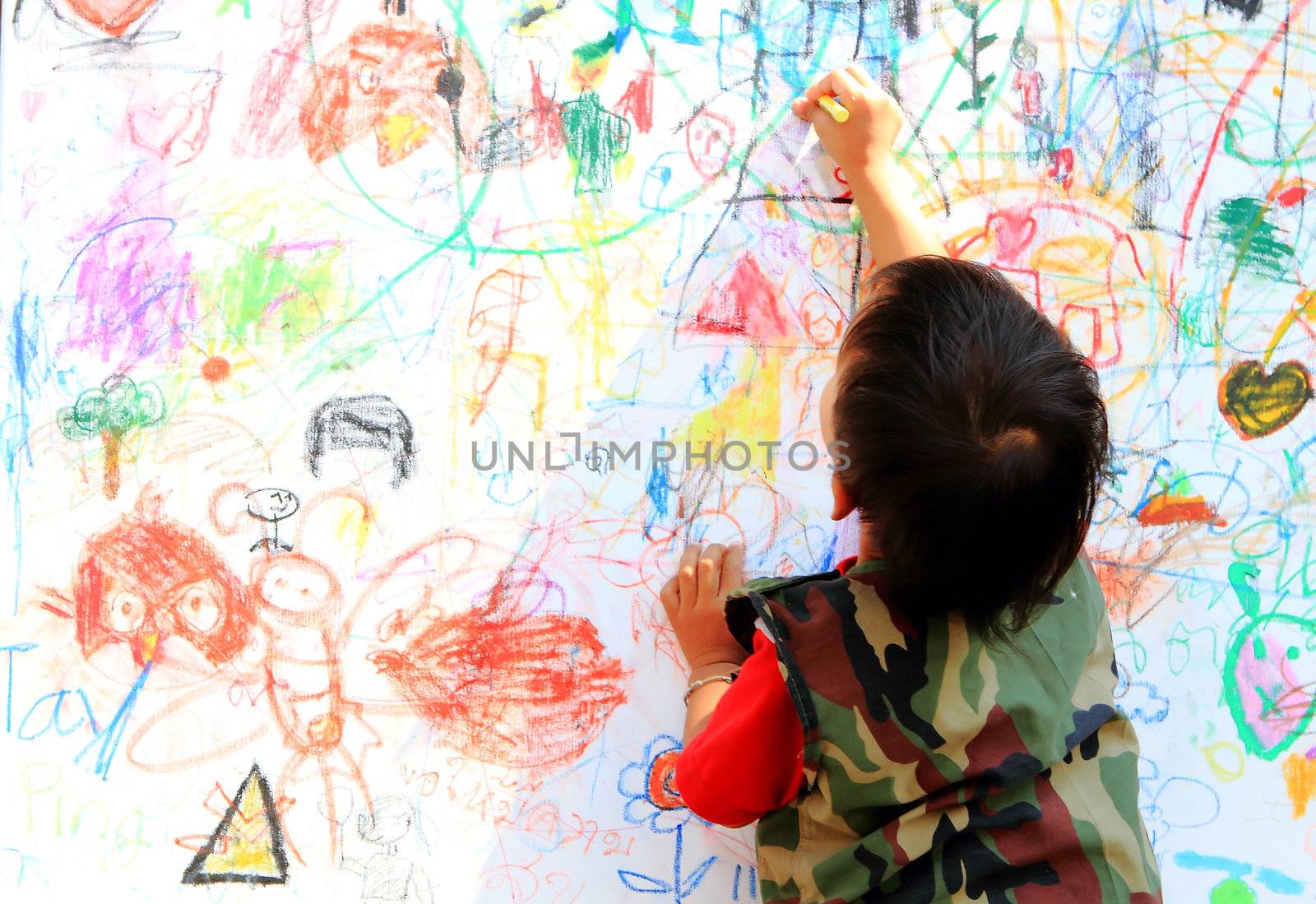 little boy draws fingers on a paper