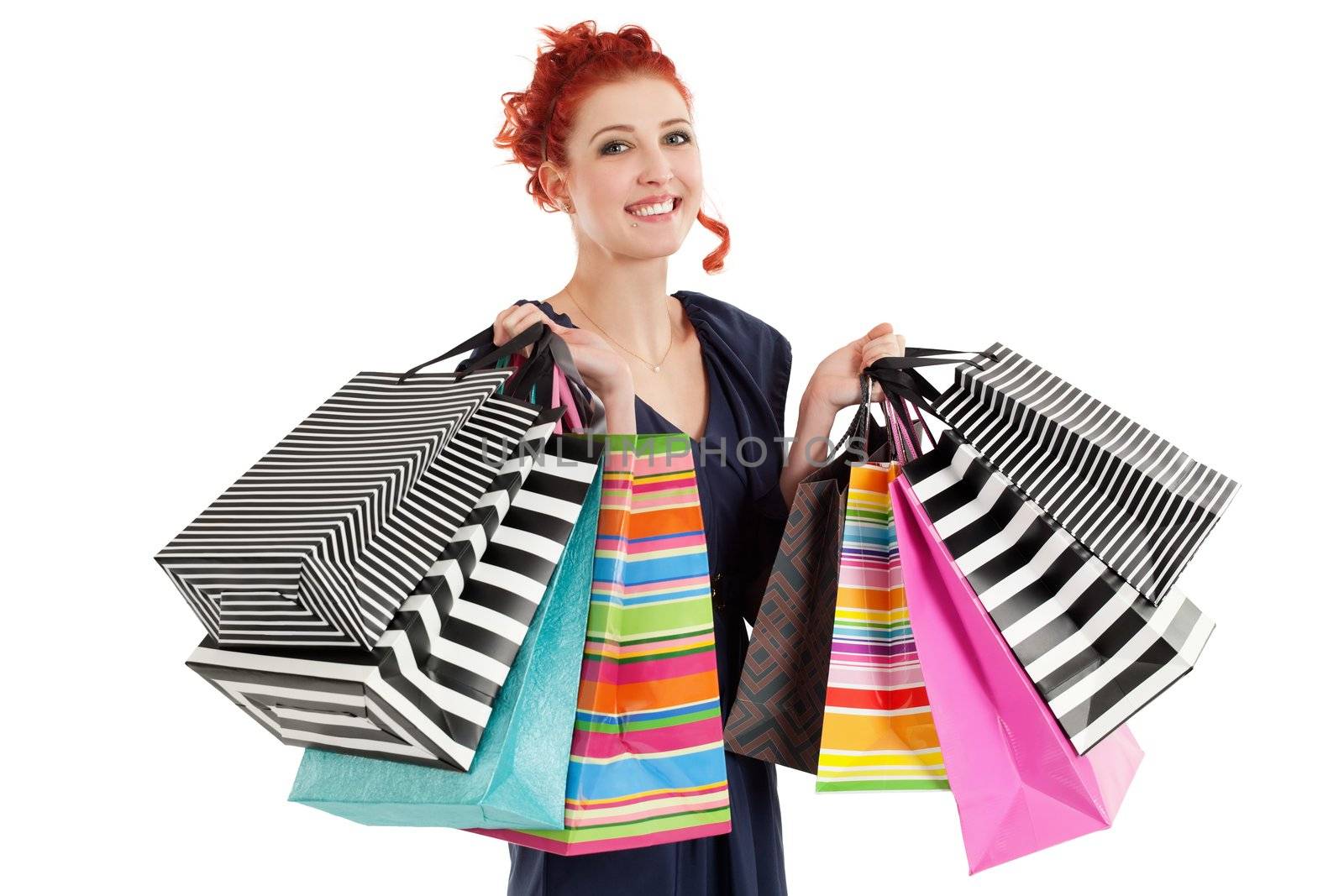 A very happy shopaholic girl holding many shopping bags and smiling about her rabid purchases.