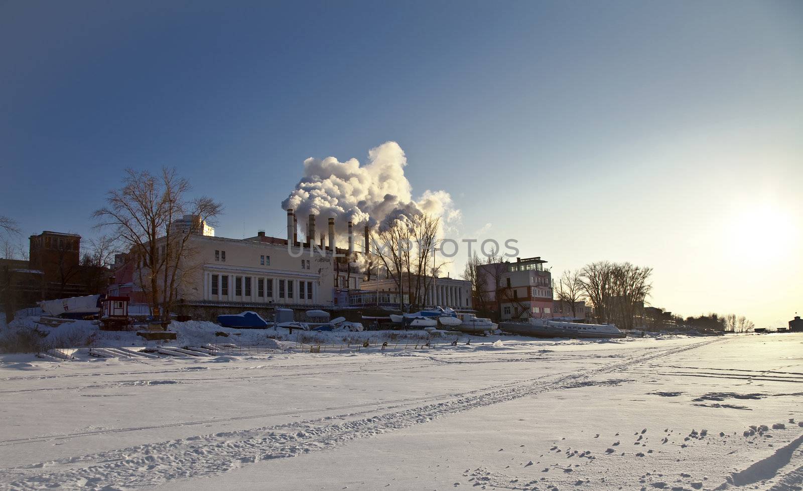 heat station on the shore of frozen river. Out of the smoke pipe is against the blue sky. Samara, Russia.