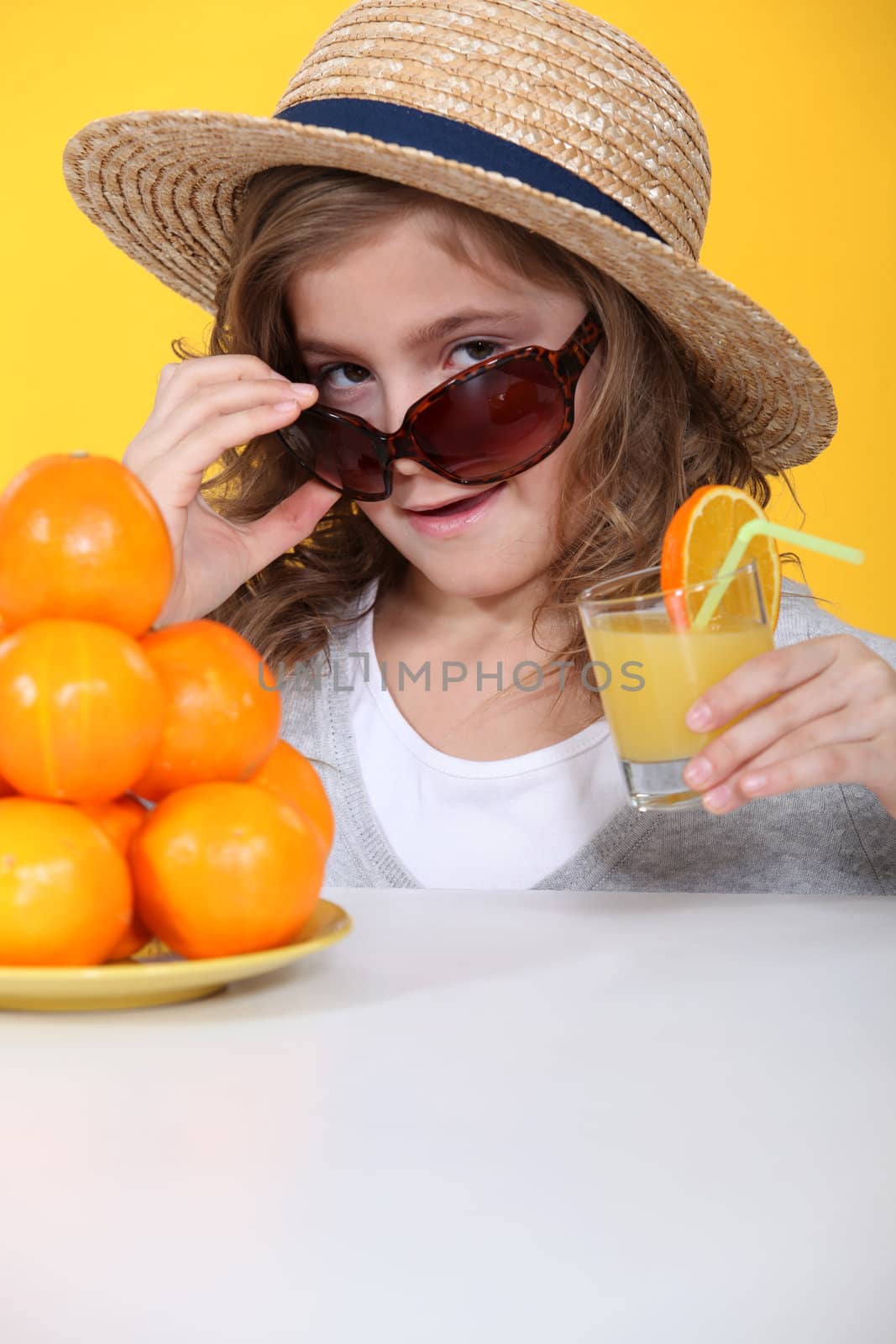 Little girl with freshly squeezed orange juice
