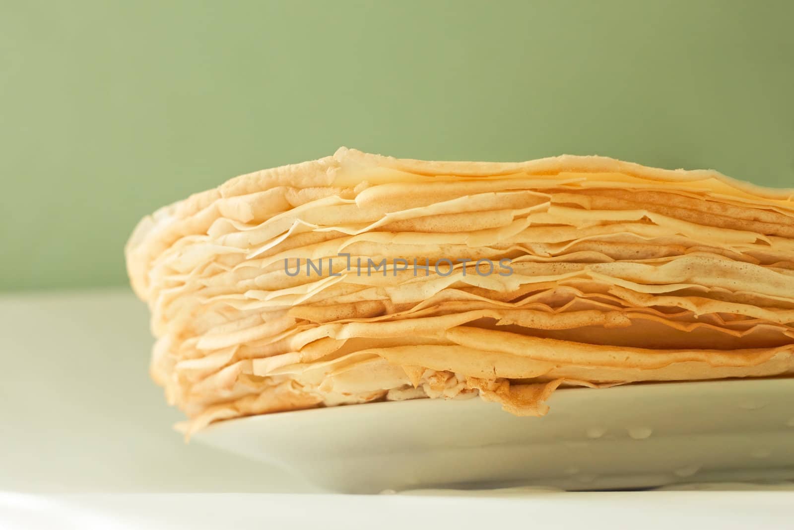 Stack of large pancakes on a plate close up
