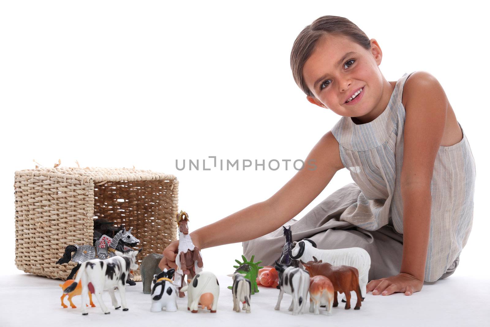 Little girl playing with toy animals by phovoir