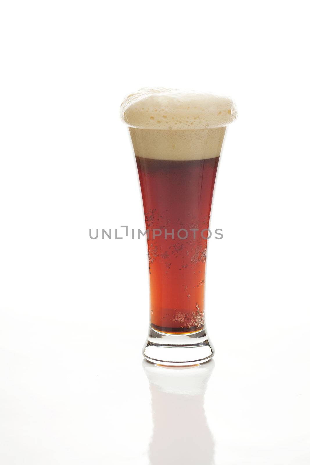 dark beer with the foam in a tall glass isolated on white