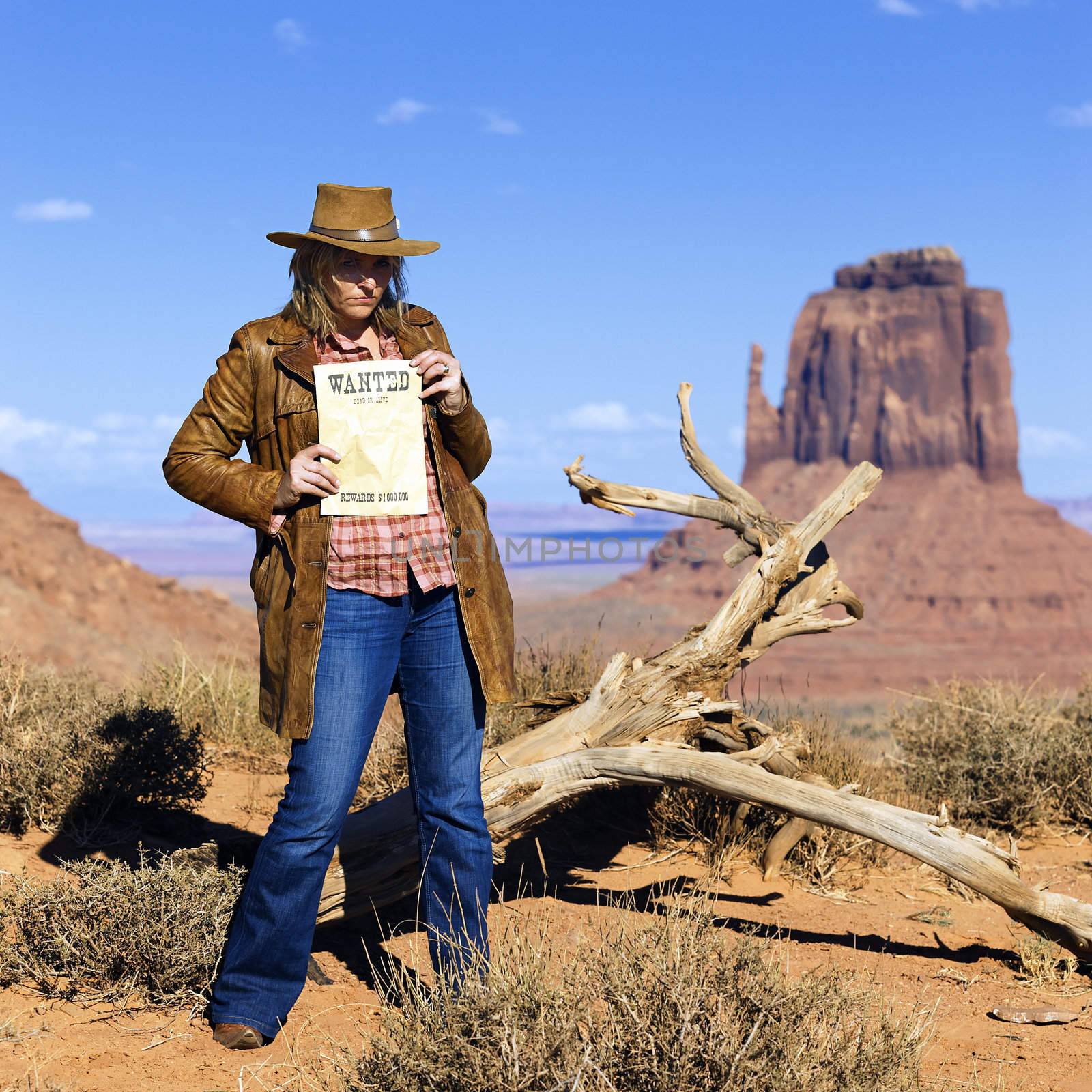 bad cowgirl holding wanted paper at Monument Valley