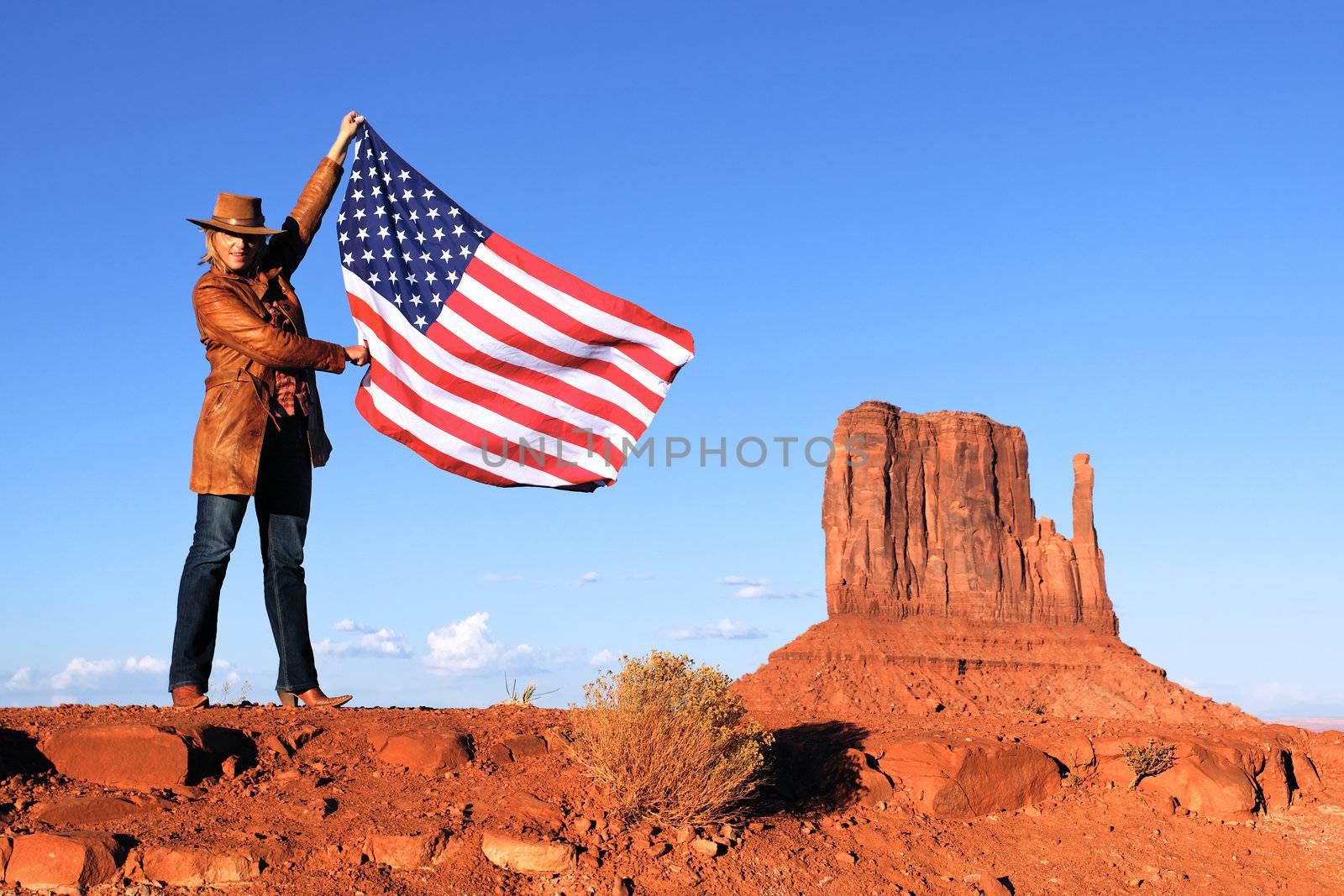young beautiful woman holding USA flag at Monument Valley