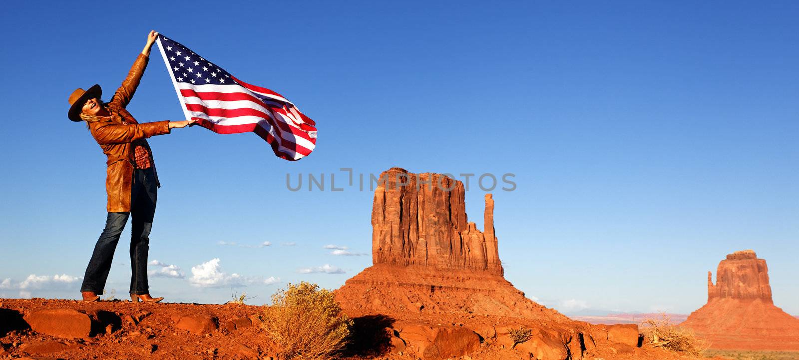 young woman holding USA flag at Monument Valley