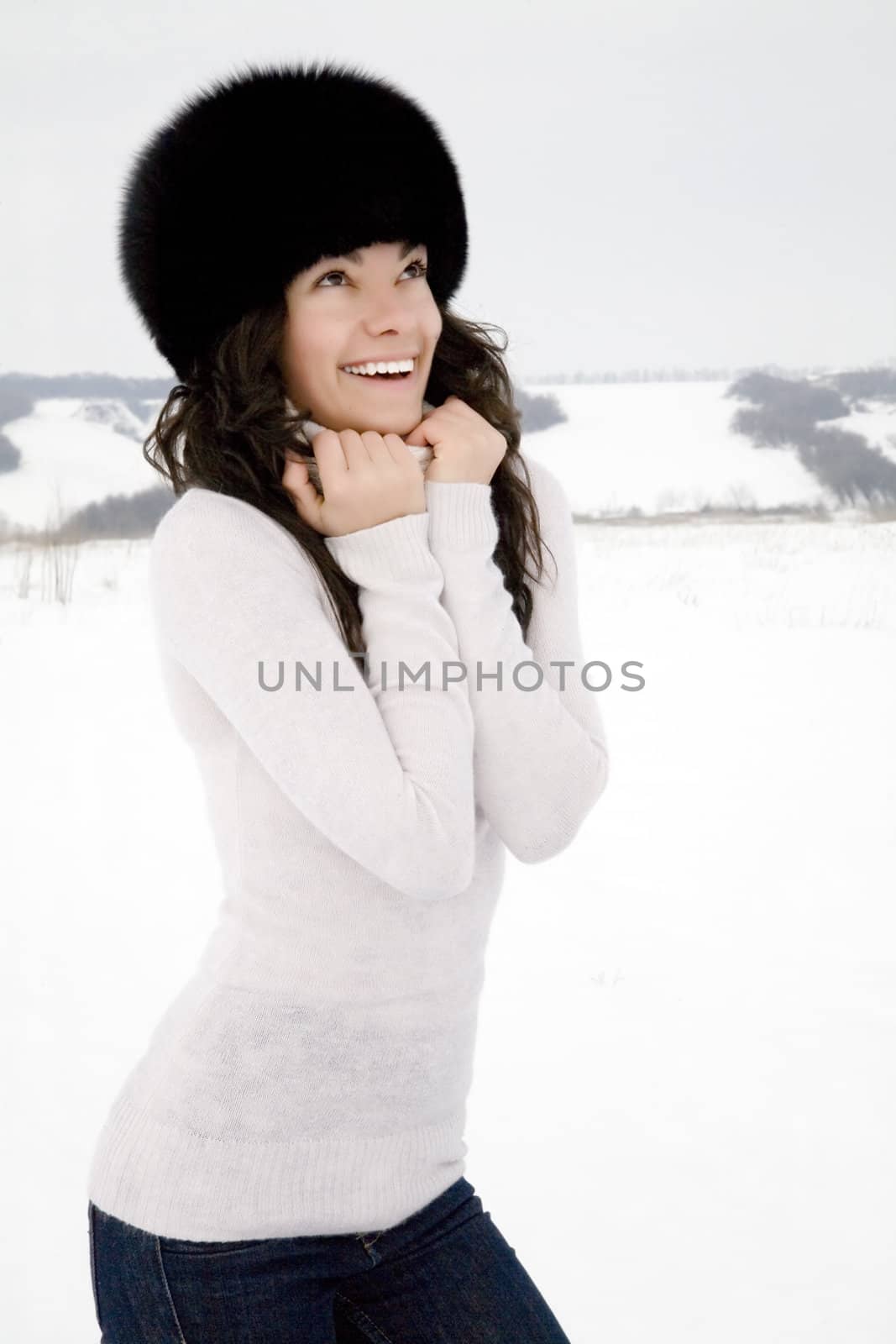 smiling attractive girl in a black fur cap in winter day