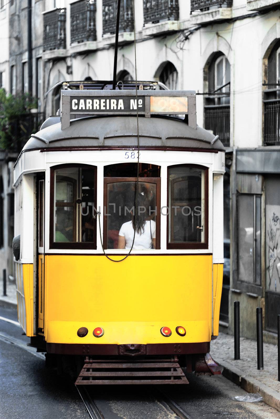 Typical yellow Tram in old Lisbon street
