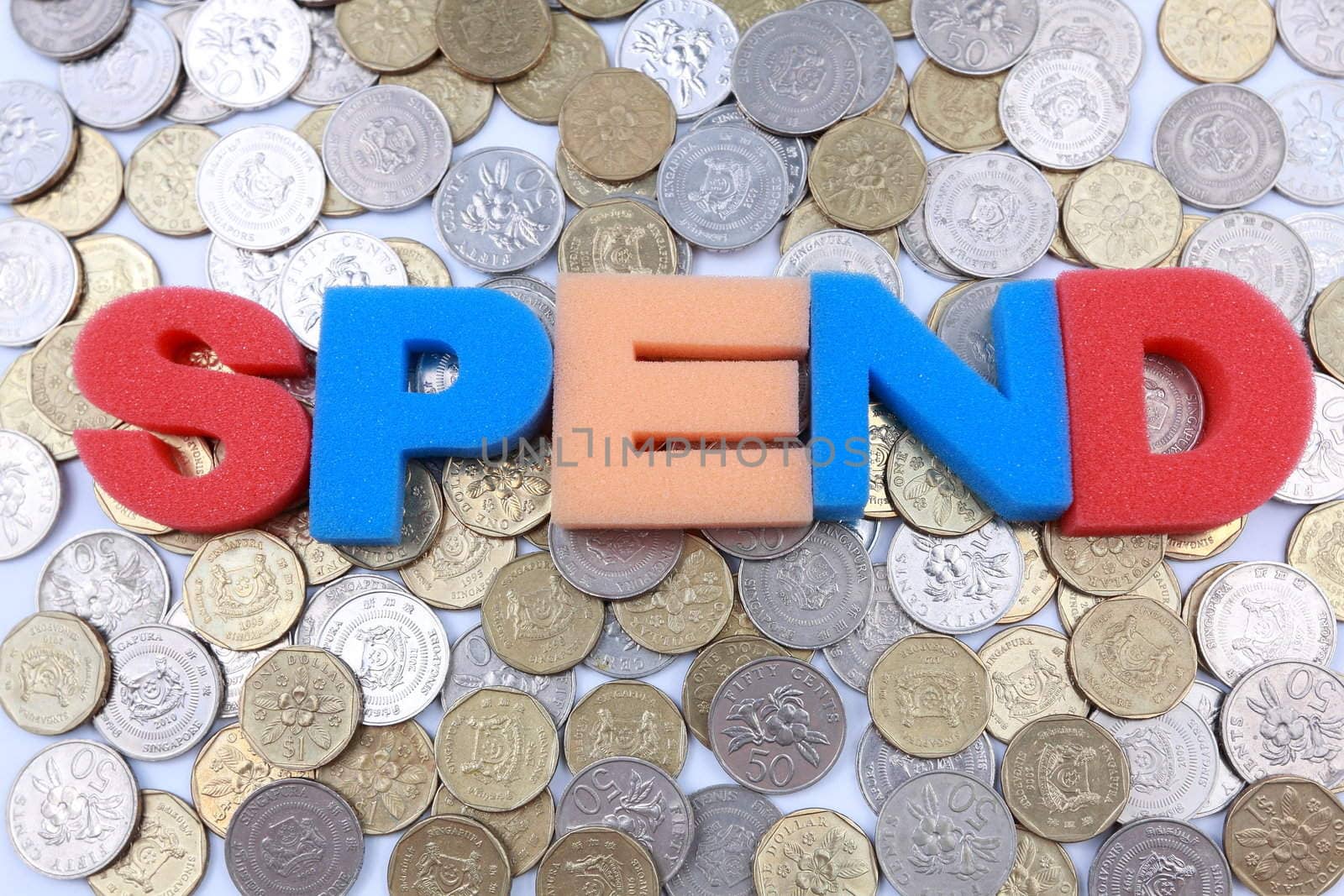 Spend word spelled out on a backdrop of coins