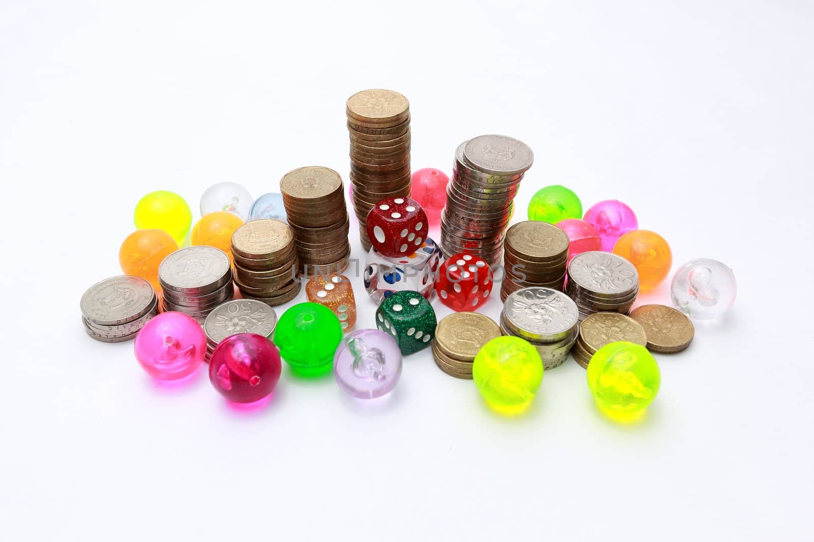 Dices surrounded by coins and colourful balls