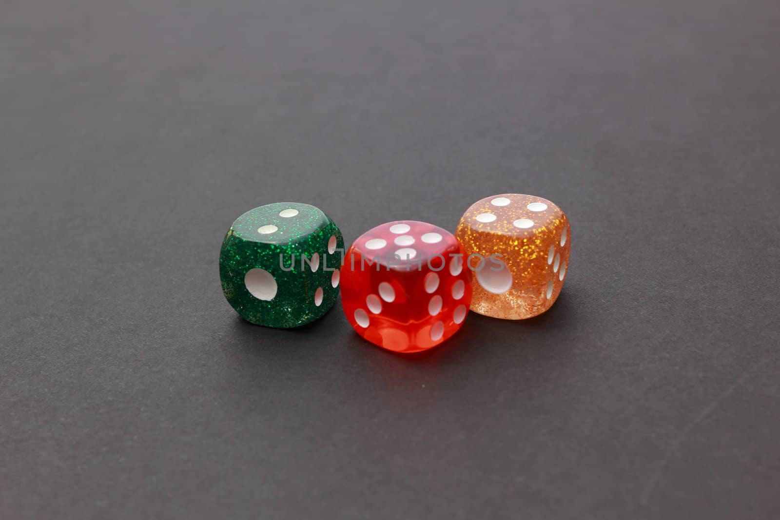 3 coloured dices on dark background