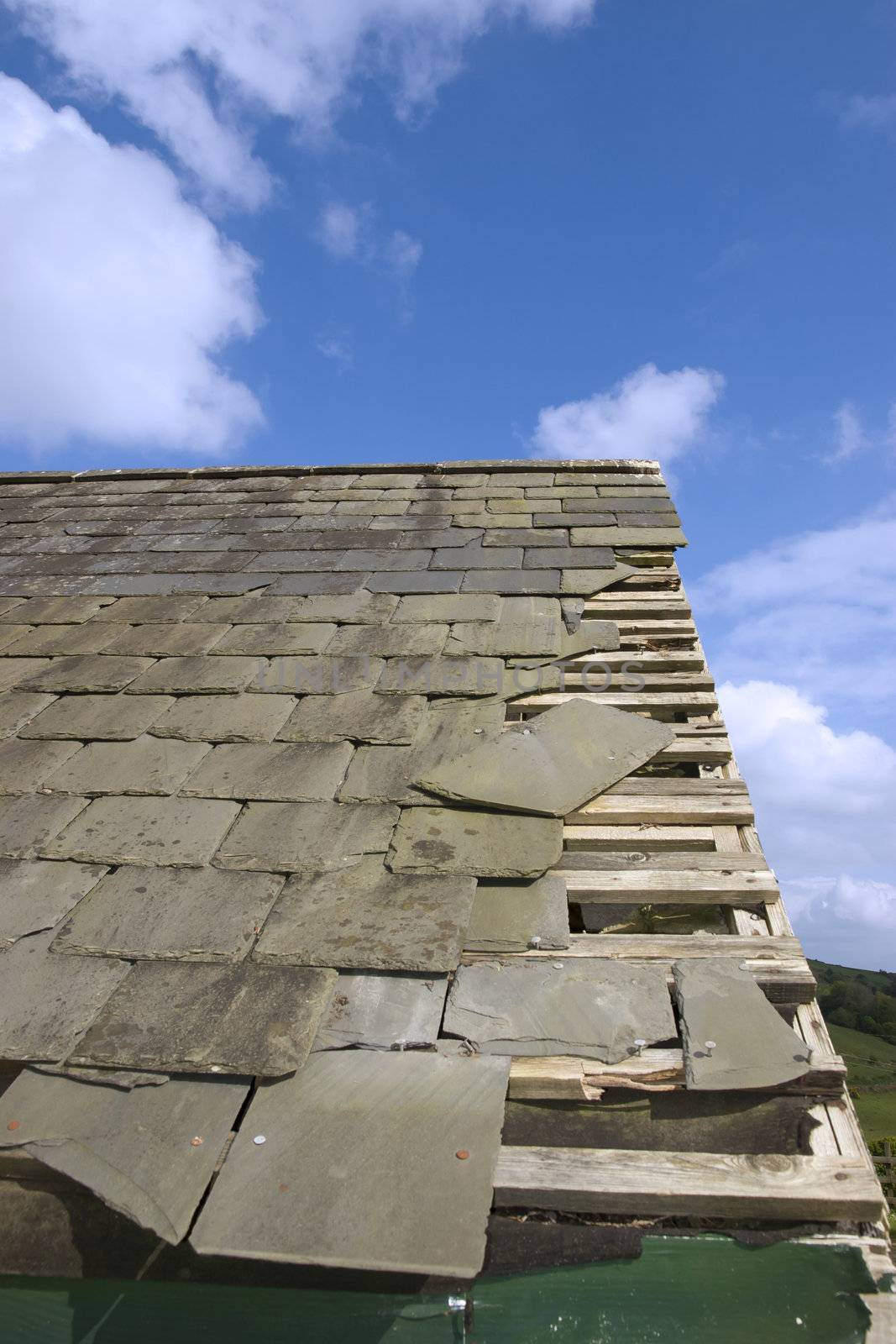 broken and fallen slate leaves holes in a roof due to storm or decay