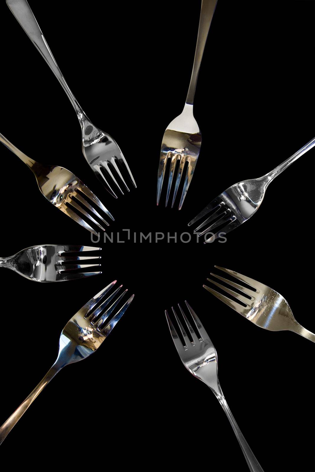 forks surrounding a heart shape petal with rose petals for a concept on romantic dining on white background