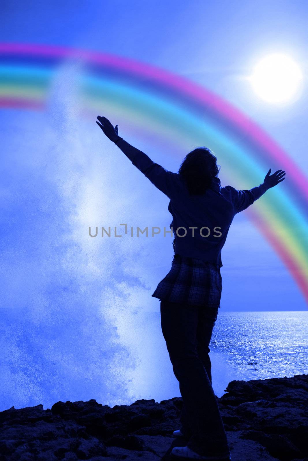 silhouette of a lone woman raising her arms in awe and praise at the power of nature