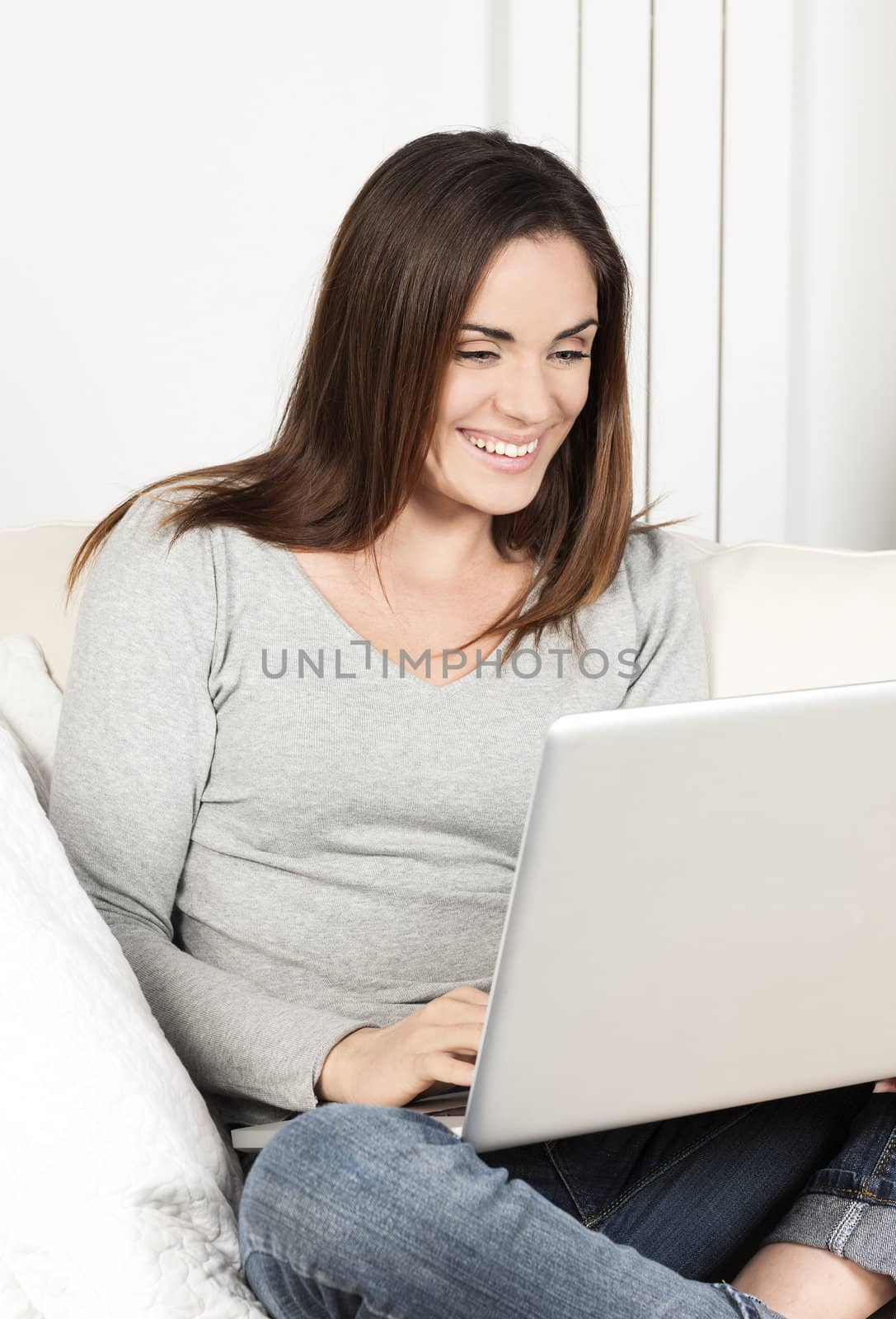 Portrait of woman using laptop on sofa