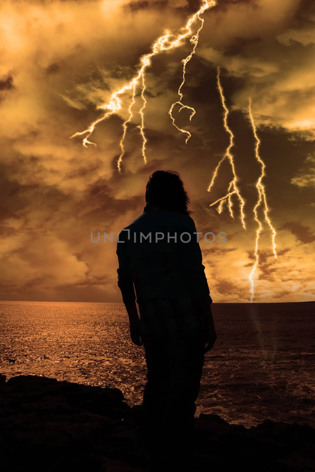 a lone woman looking sadly over the cliffs edge in county clare ireland during a thunder storm