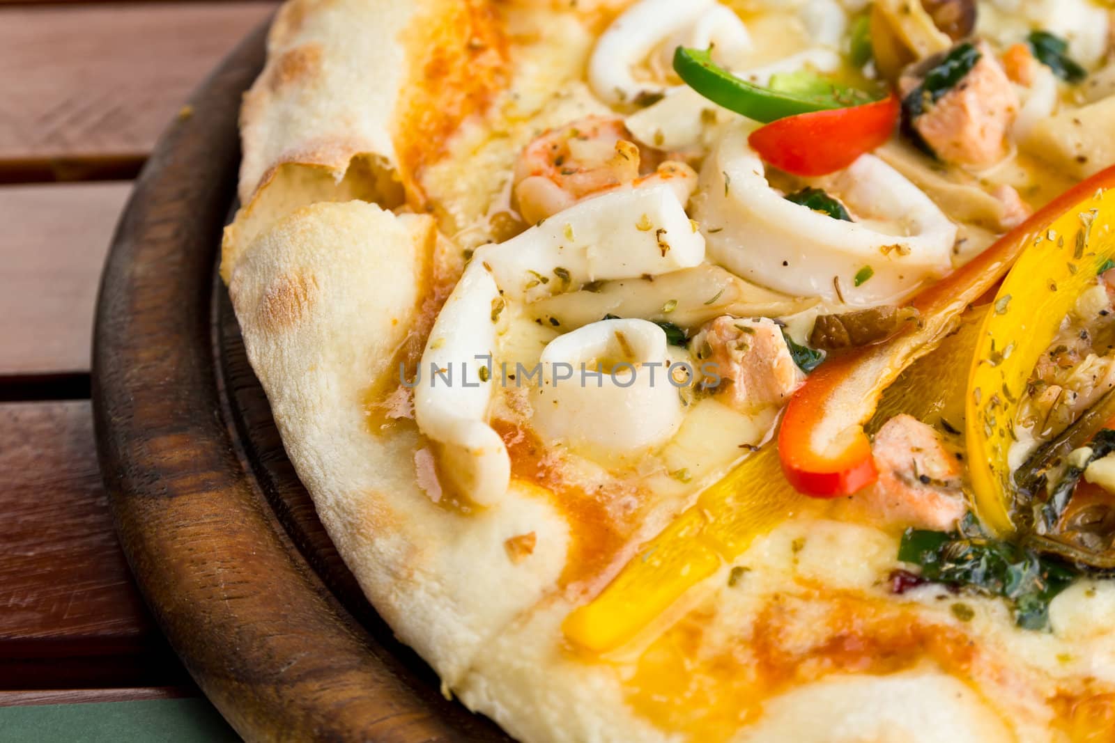 Closeup delicious pizza with seafood on wooden stand