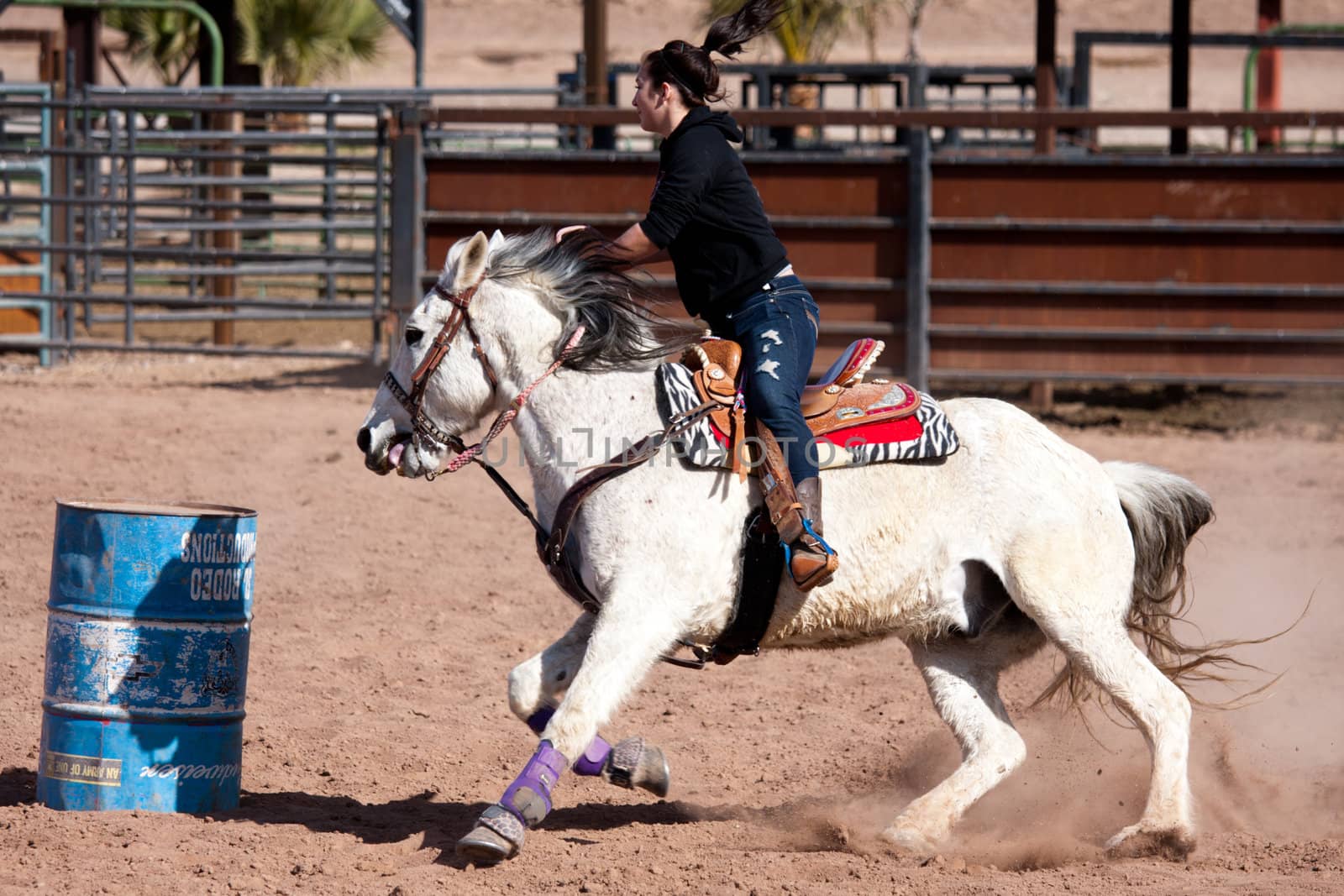 Women horse barrel race in corral in las vegas