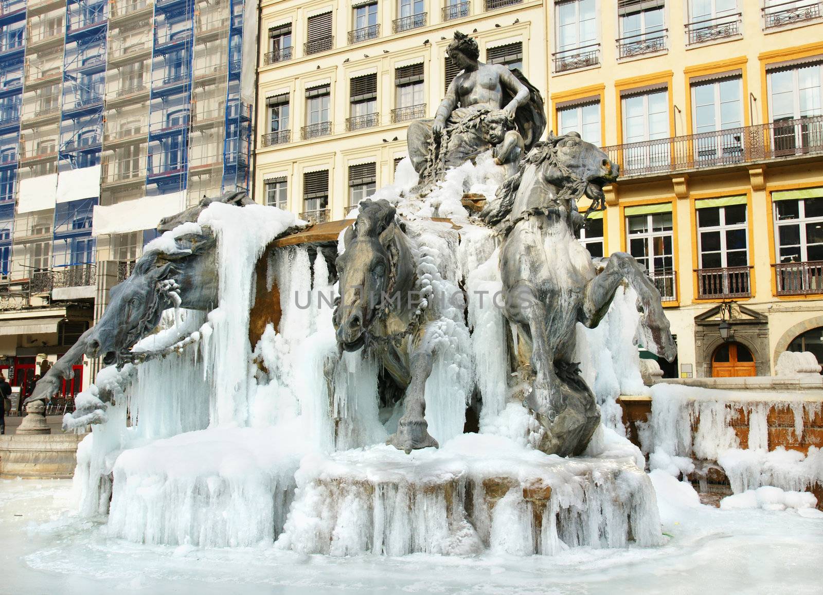 Cold climate: frozen Bartholdi fountain with bronze horse and statues coming out of ice, at the place des terreaux, Lyon, France.