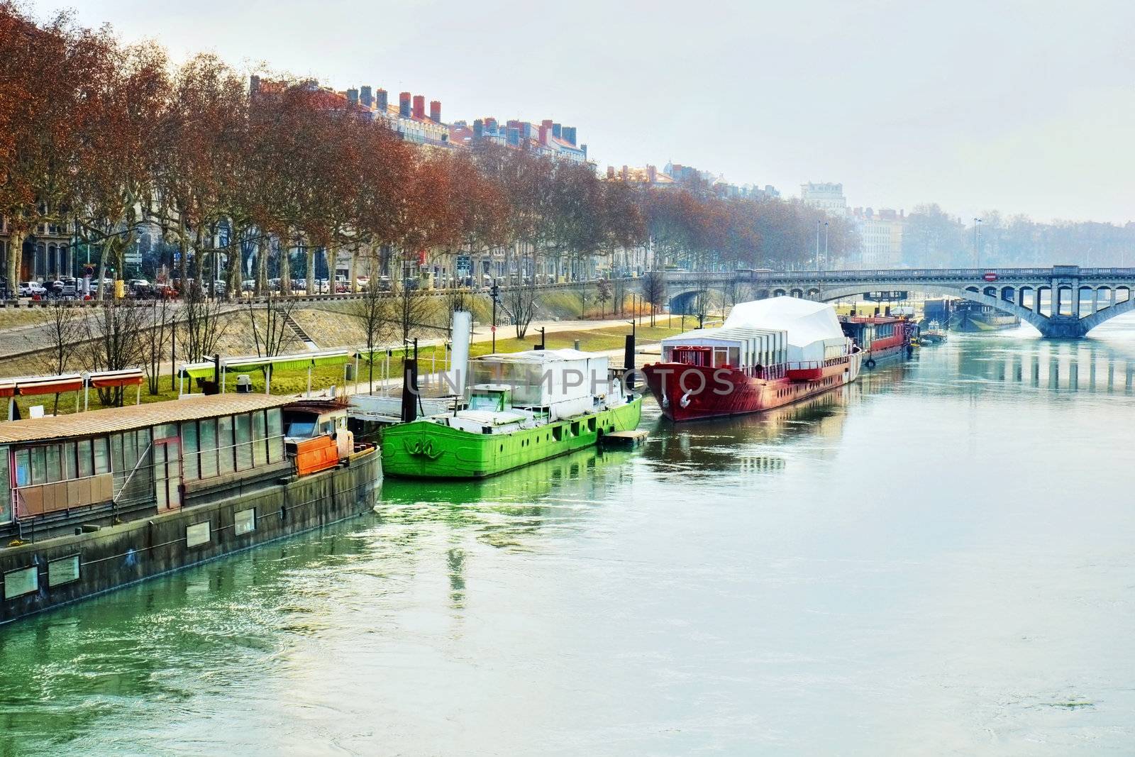 Damatic HDR rendering of a beautiful scene or landscape of houseboats or barges with their freight along the banks of the Rhone river, Lyon, France on a misty morning.