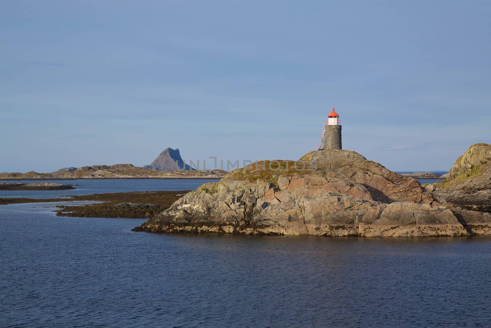 Small lighthouse on rocky islands on norwegian coast near Lofoten islands