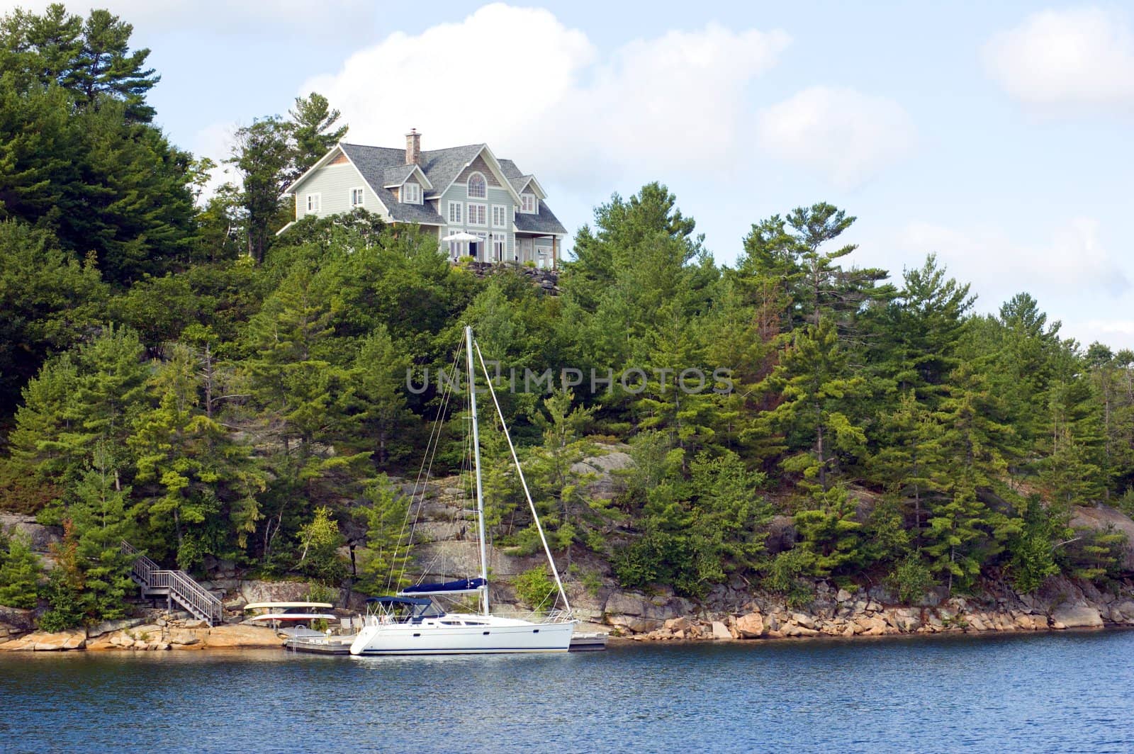 Lone cottage on high stone lake shore