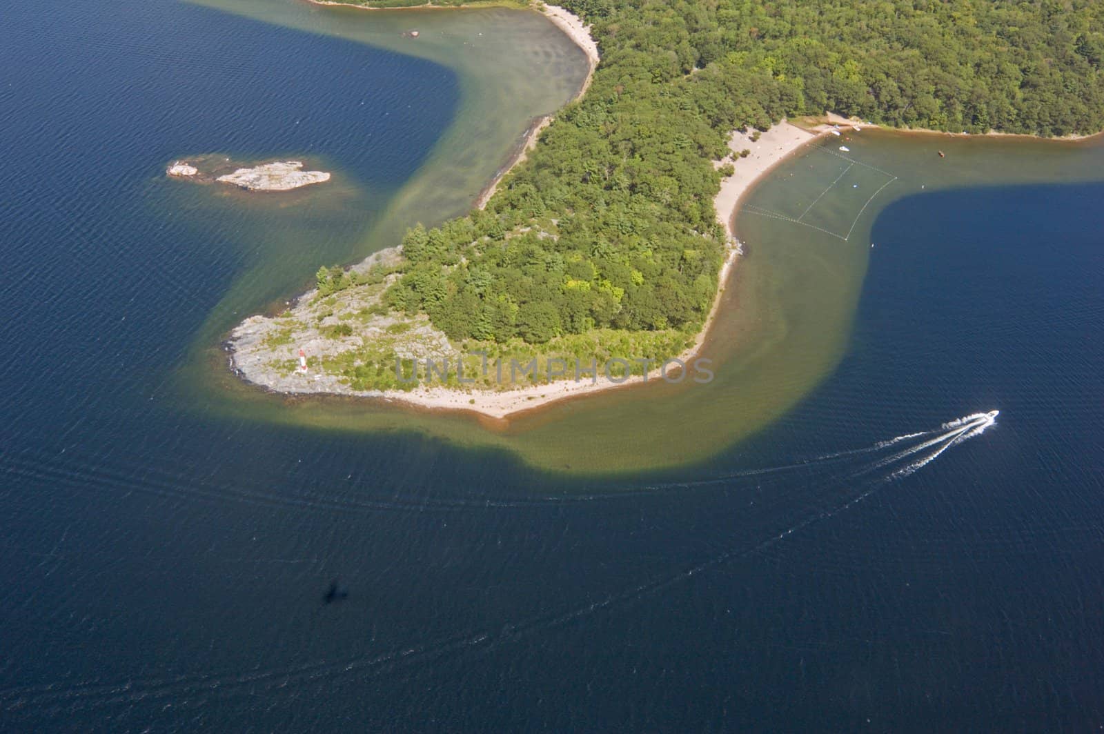Small boat tracks on surface of water in sunlit