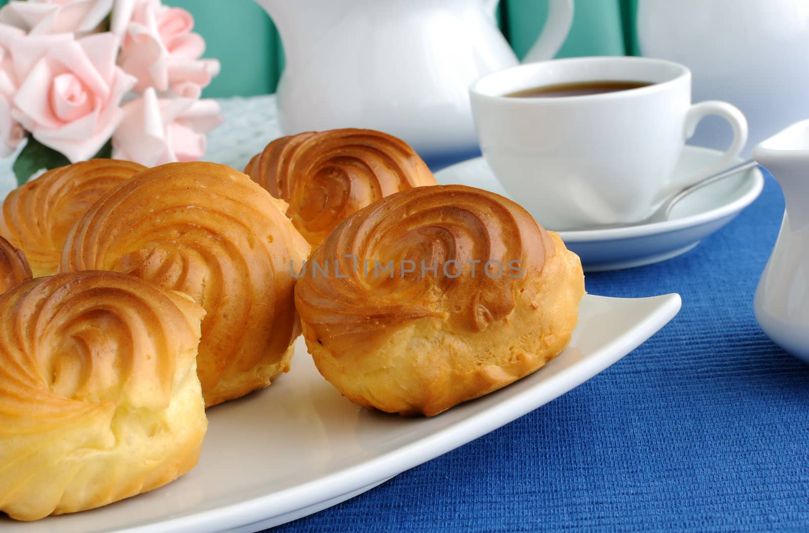 Eclairs close-up on a plate with a cup of coffee