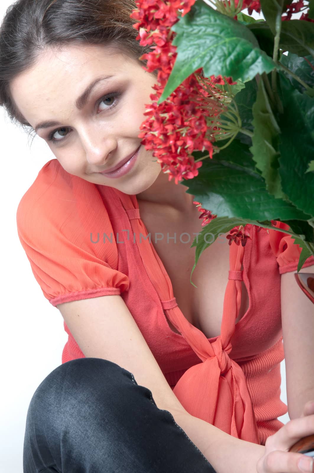 Portrait of a young beautiful girl with a bouquet of red flowers in vase