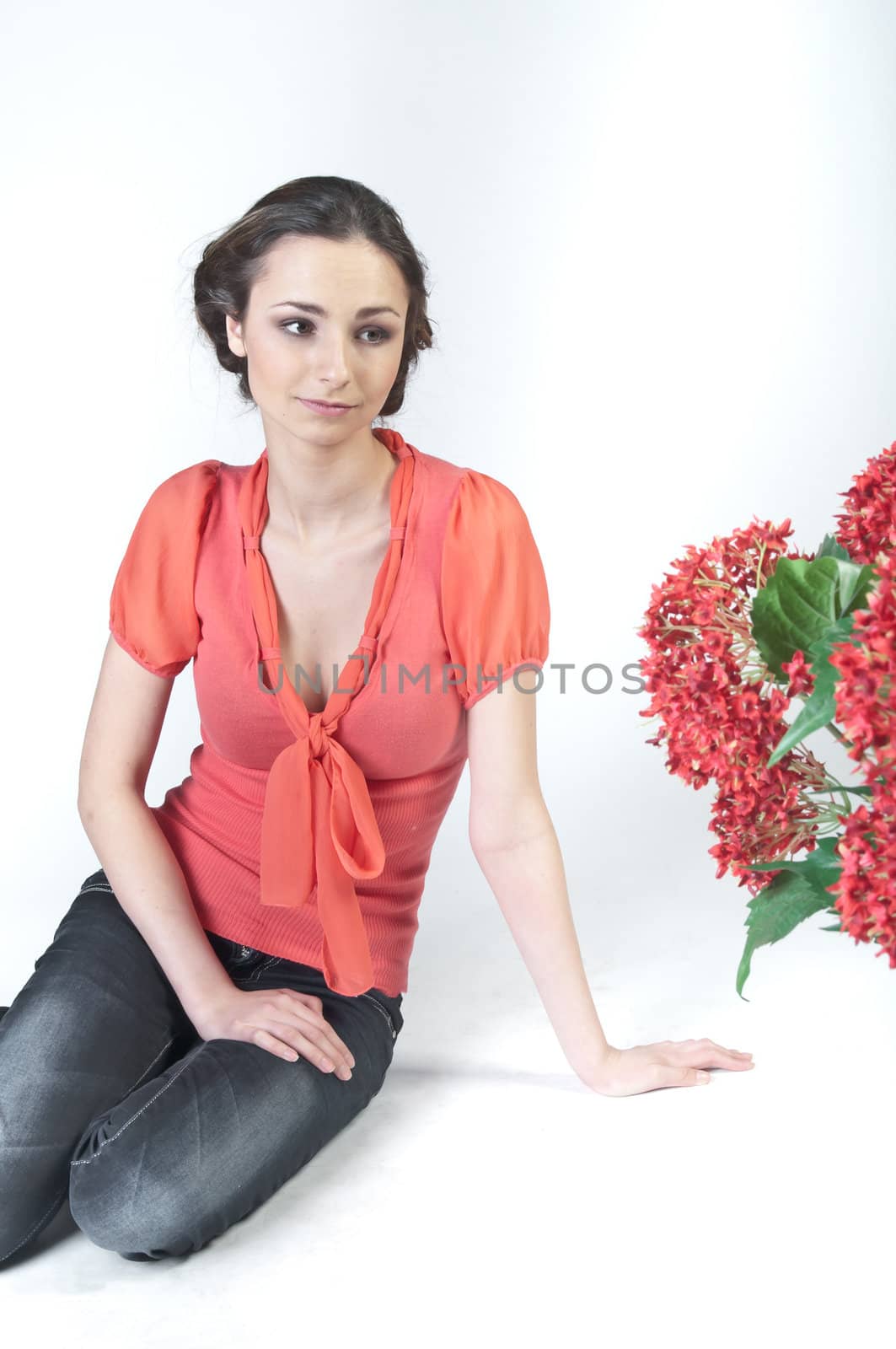 Portrait of a young beautiful girl with a bouquet of red flowers in vase