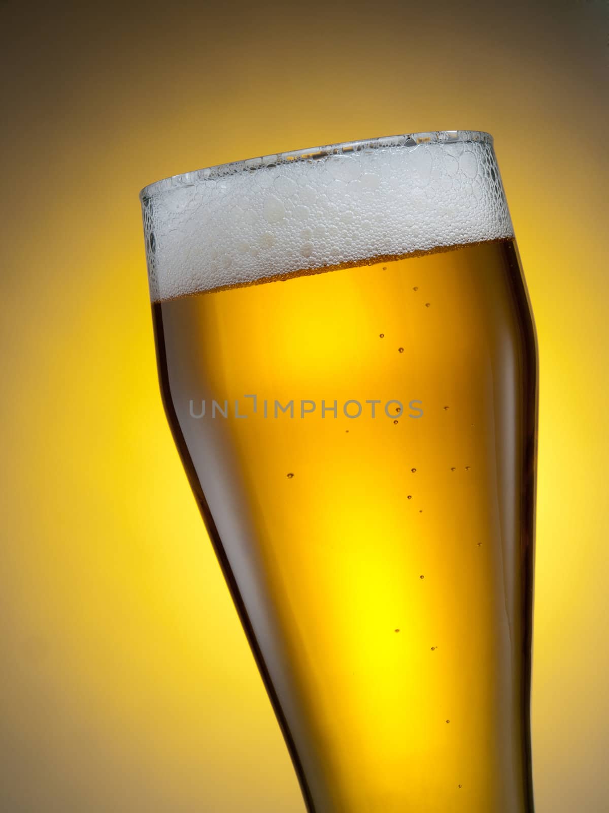 A glass of beer against yellow background