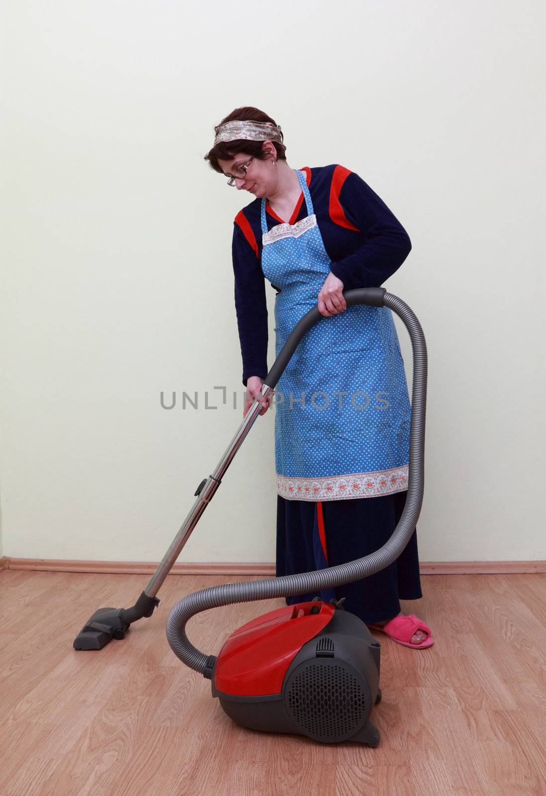 Housewife using a vacuum cleaner to clean the floor.