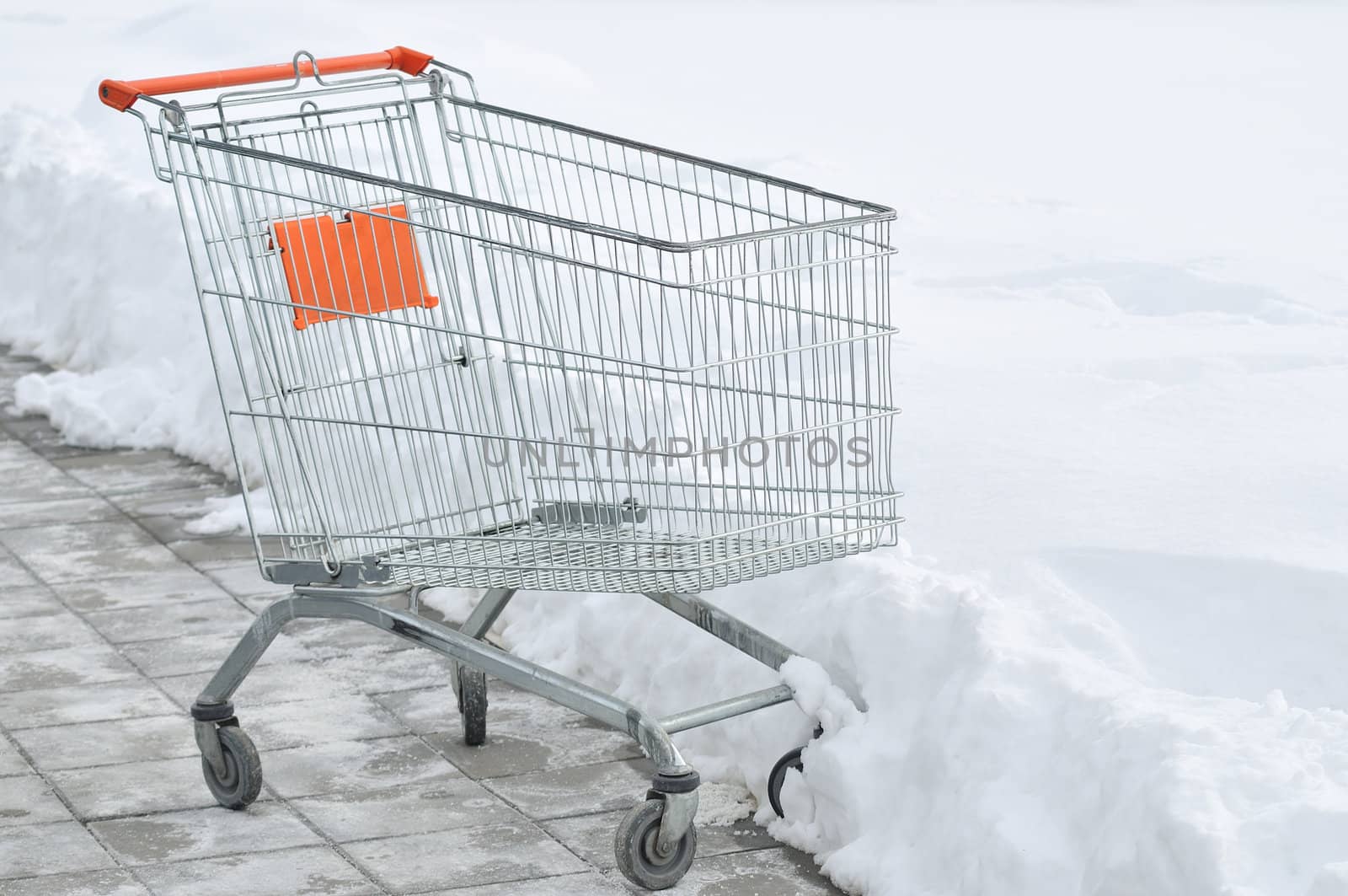Metal shopping carts at supermarket parking covered with snow