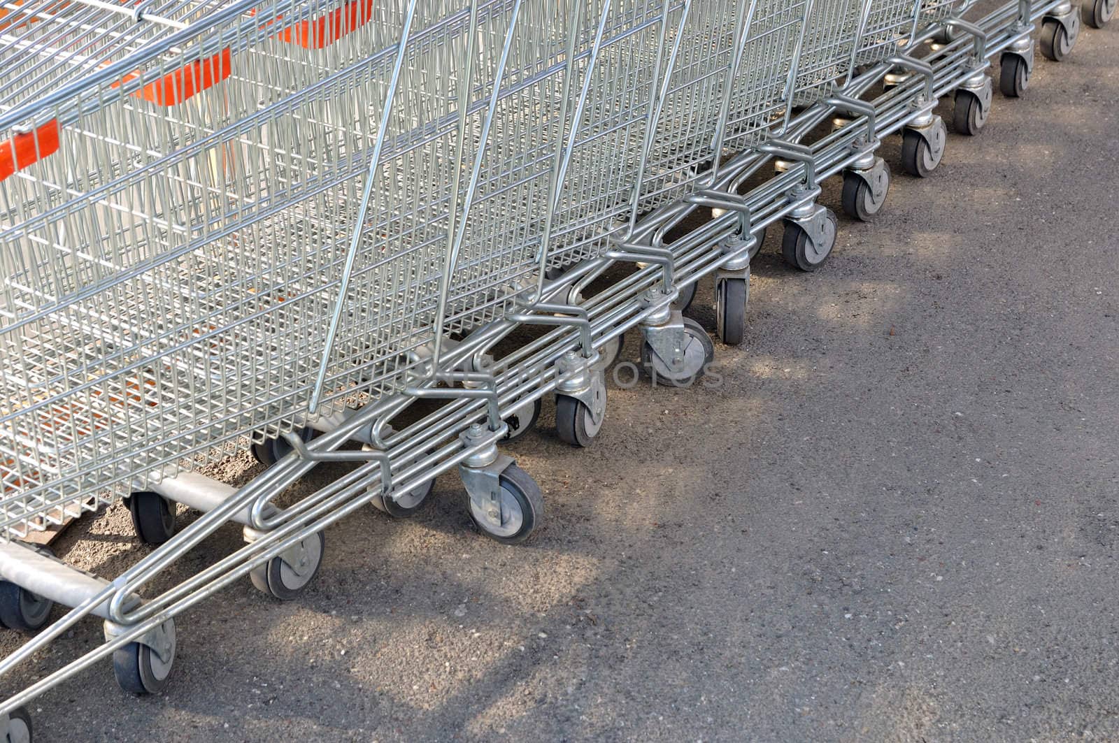 Row of metal shopping carts at supermarket parking