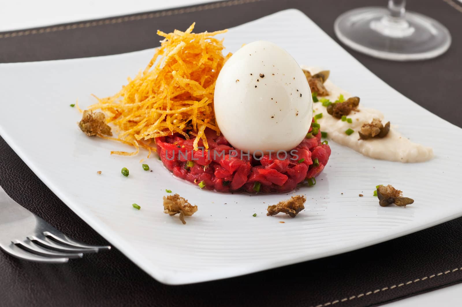 Gourmet dish with egg and raw meat. Studio shot. 