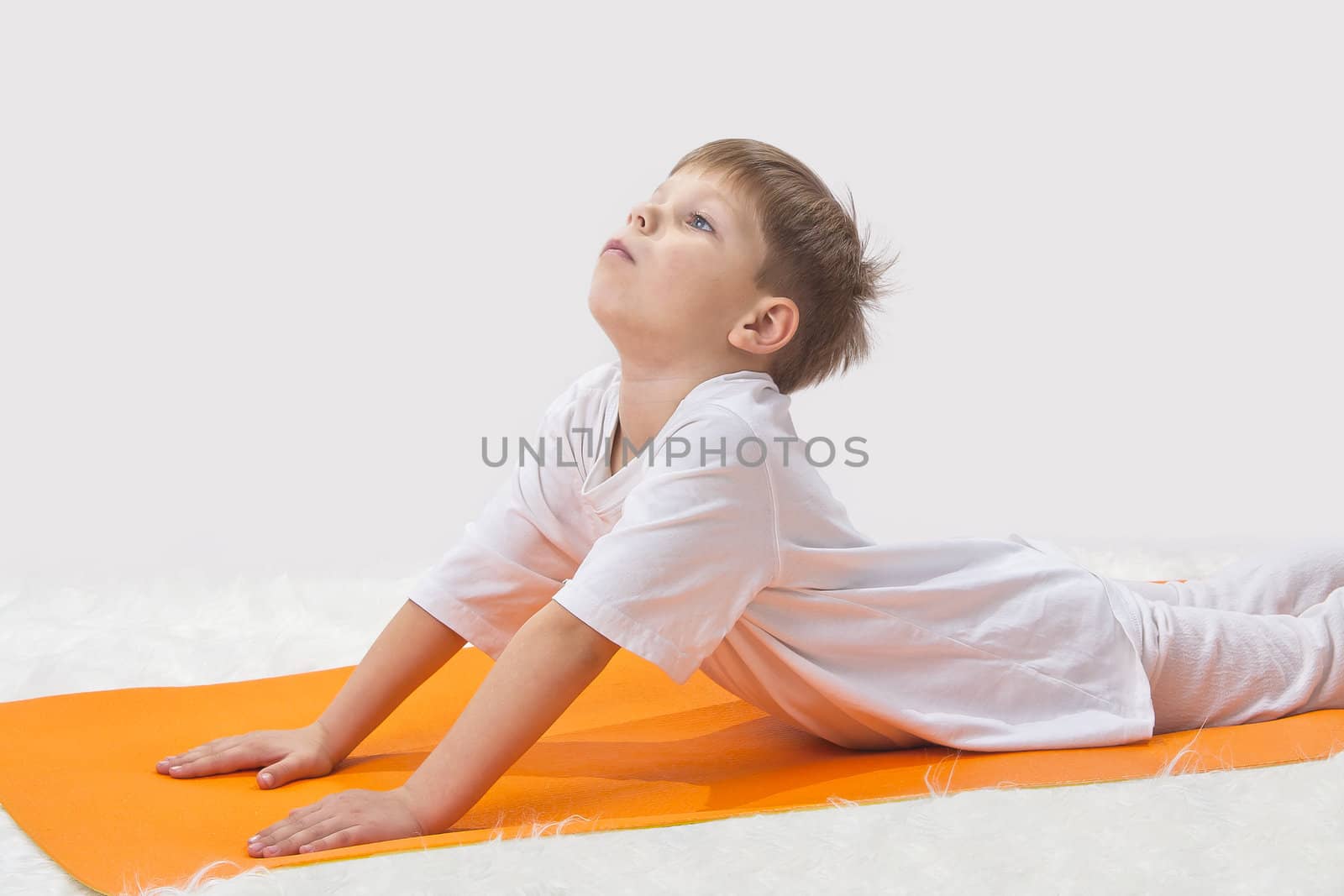 Children's yoga. The little boy does exercise. 