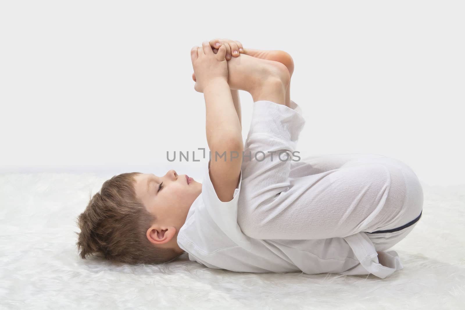 Children's yoga. The little boy does exercise. 