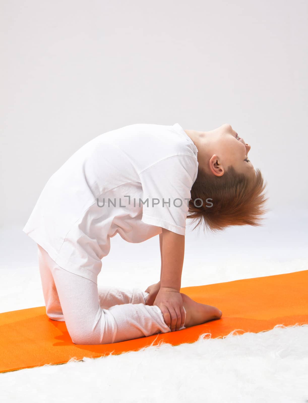 Children's yoga. The little boy does exercise. by NickNick
