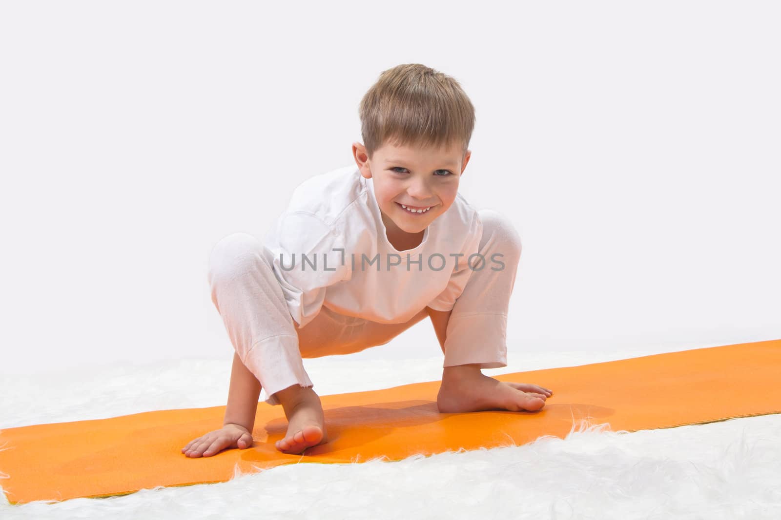 Children's yoga. The little boy does exercise. 