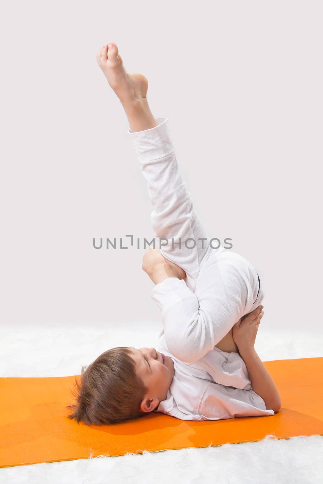 Children's yoga. The little boy does exercise.