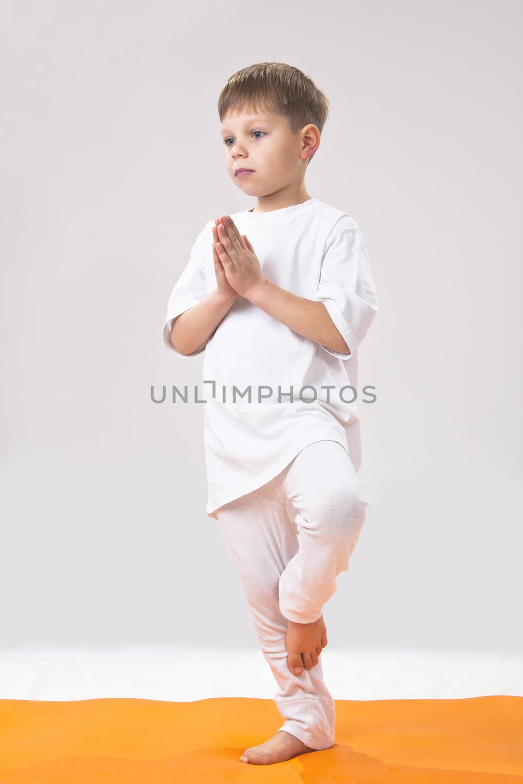 Children's yoga. The little boy does exercise.  by NickNick