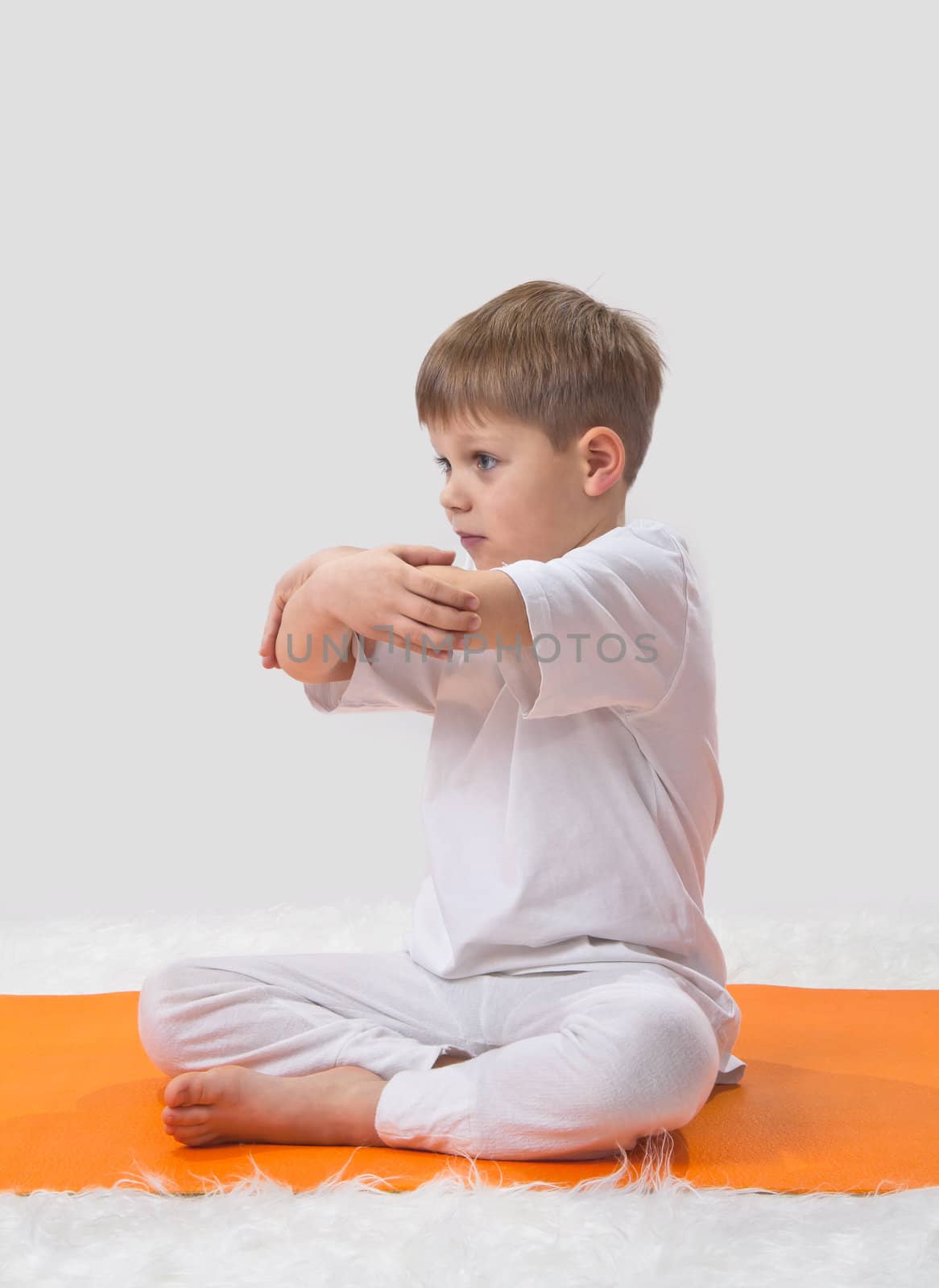 Children's yoga. The little boy does exercise. 