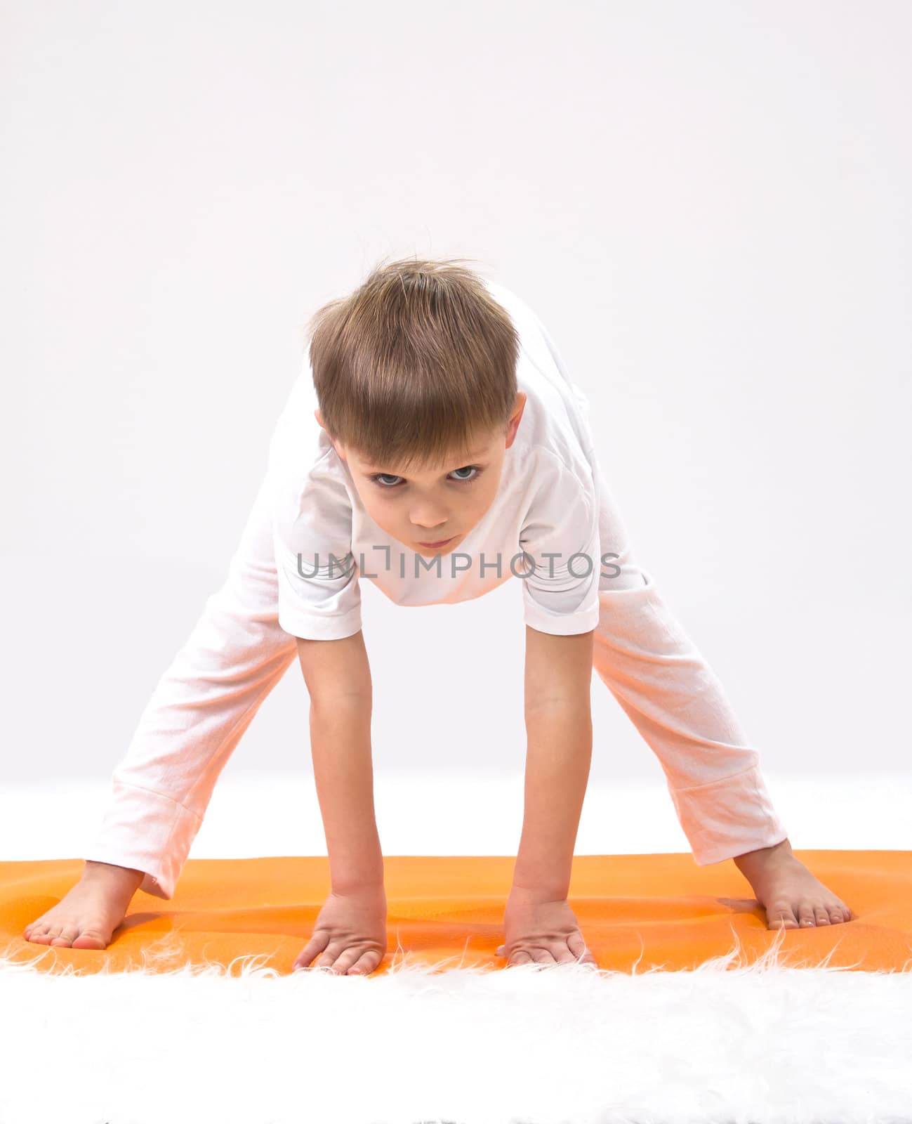 Children's yoga. The little boy does exercise. 