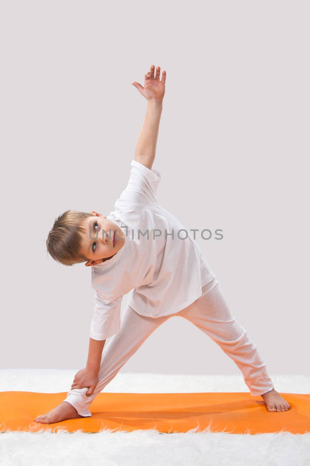 Children's yoga. The little boy does exercise.  by NickNick