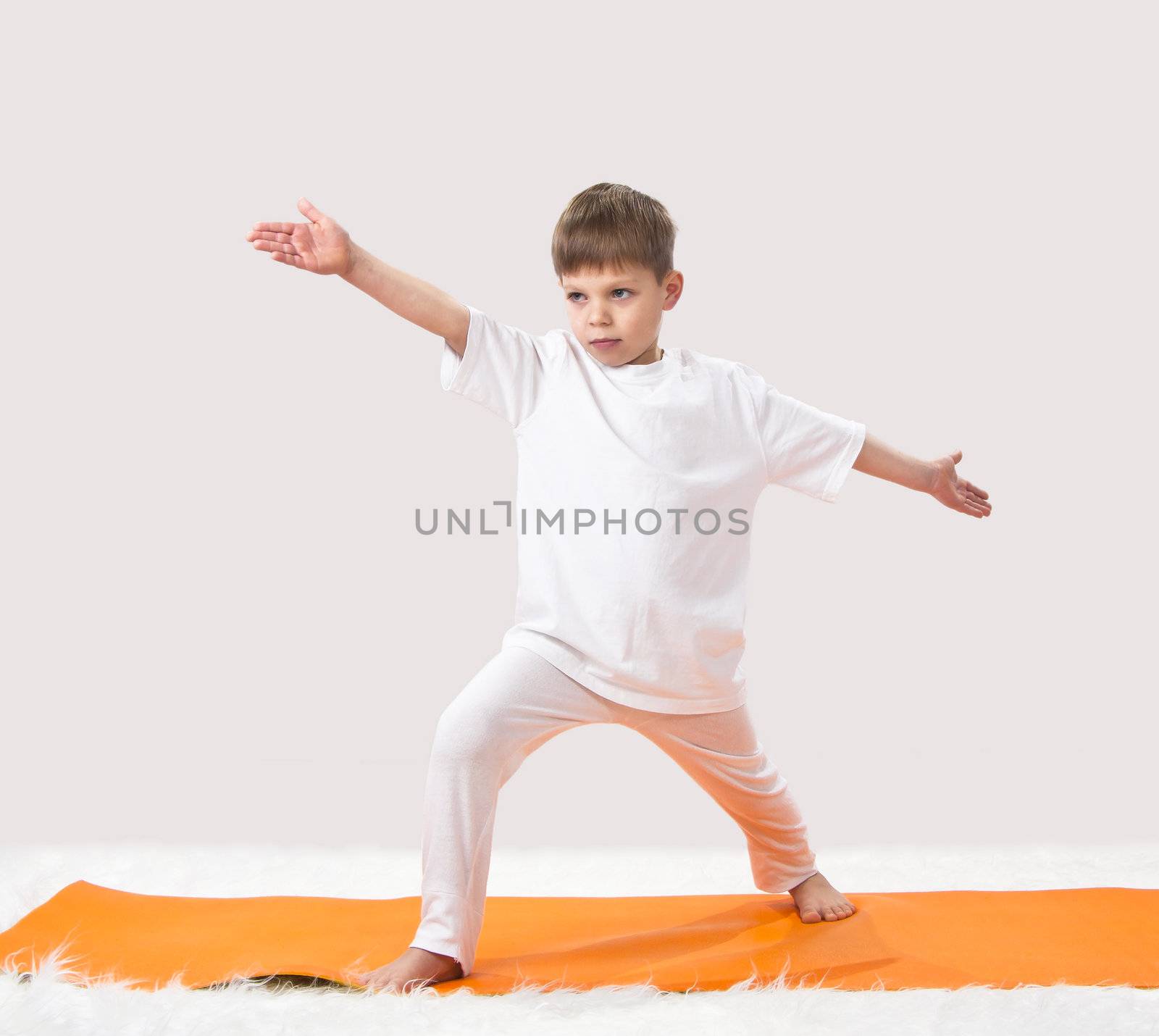 Children's yoga. The little boy does exercise. 