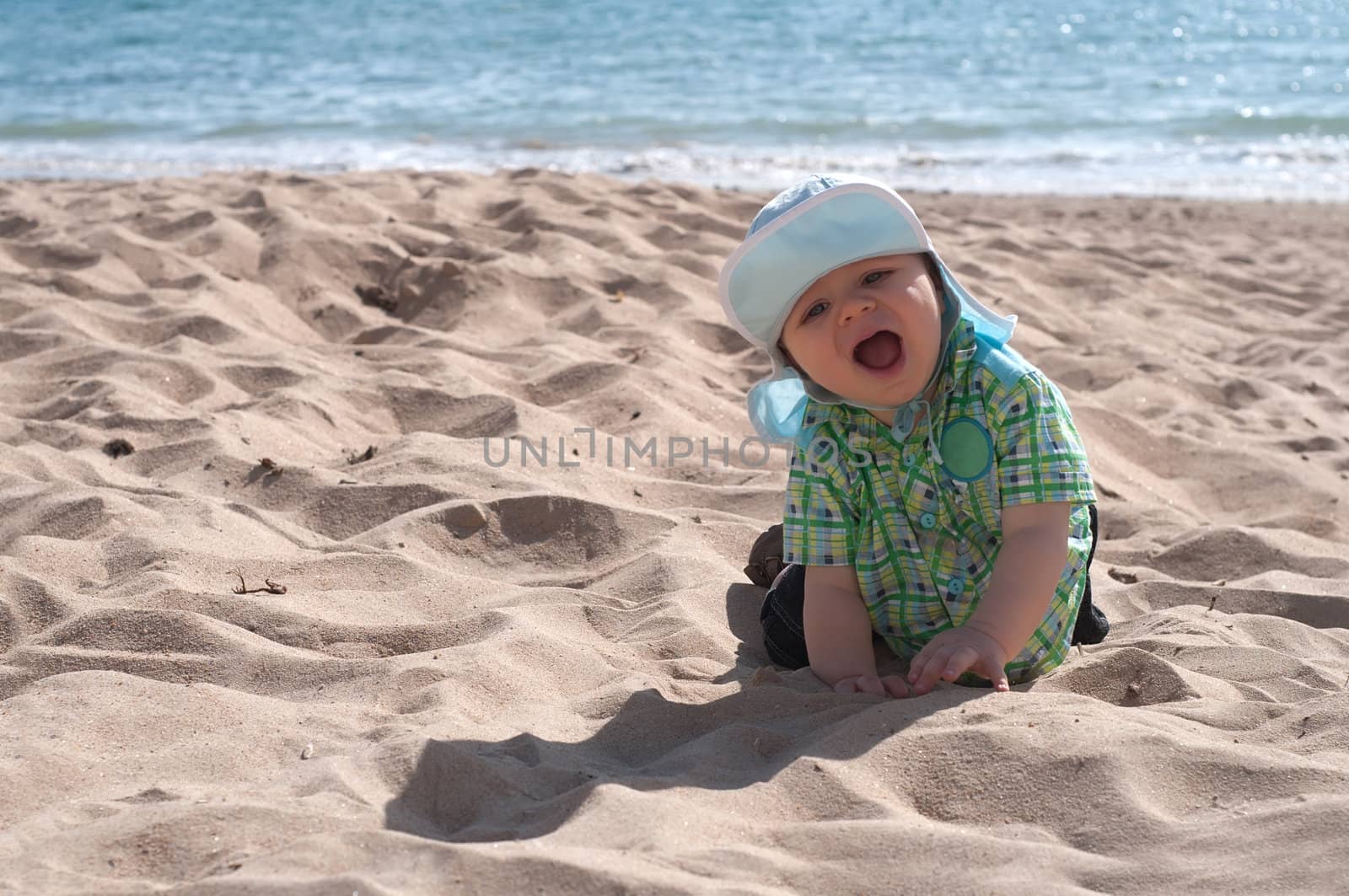 Happy baby boy on the beach by anytka