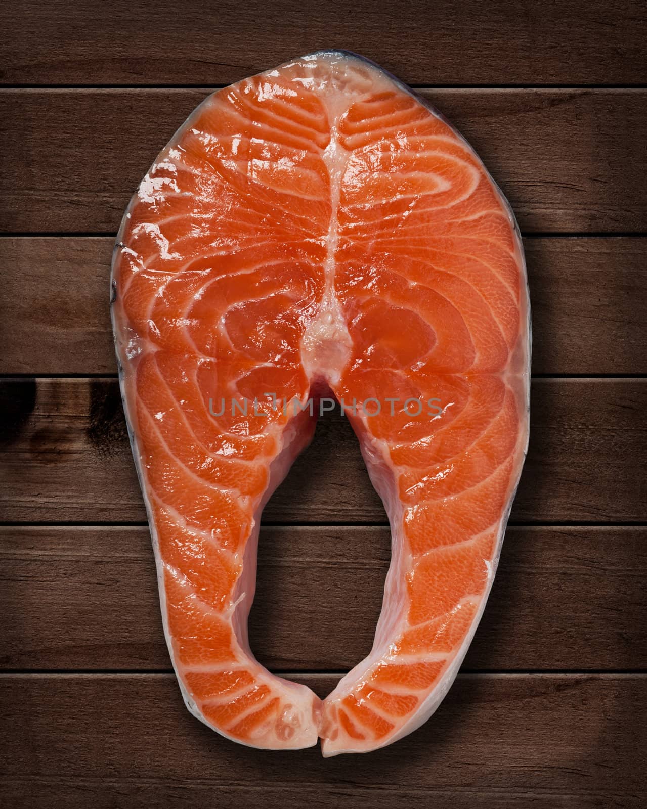 Red salmon steak on wooden  table.