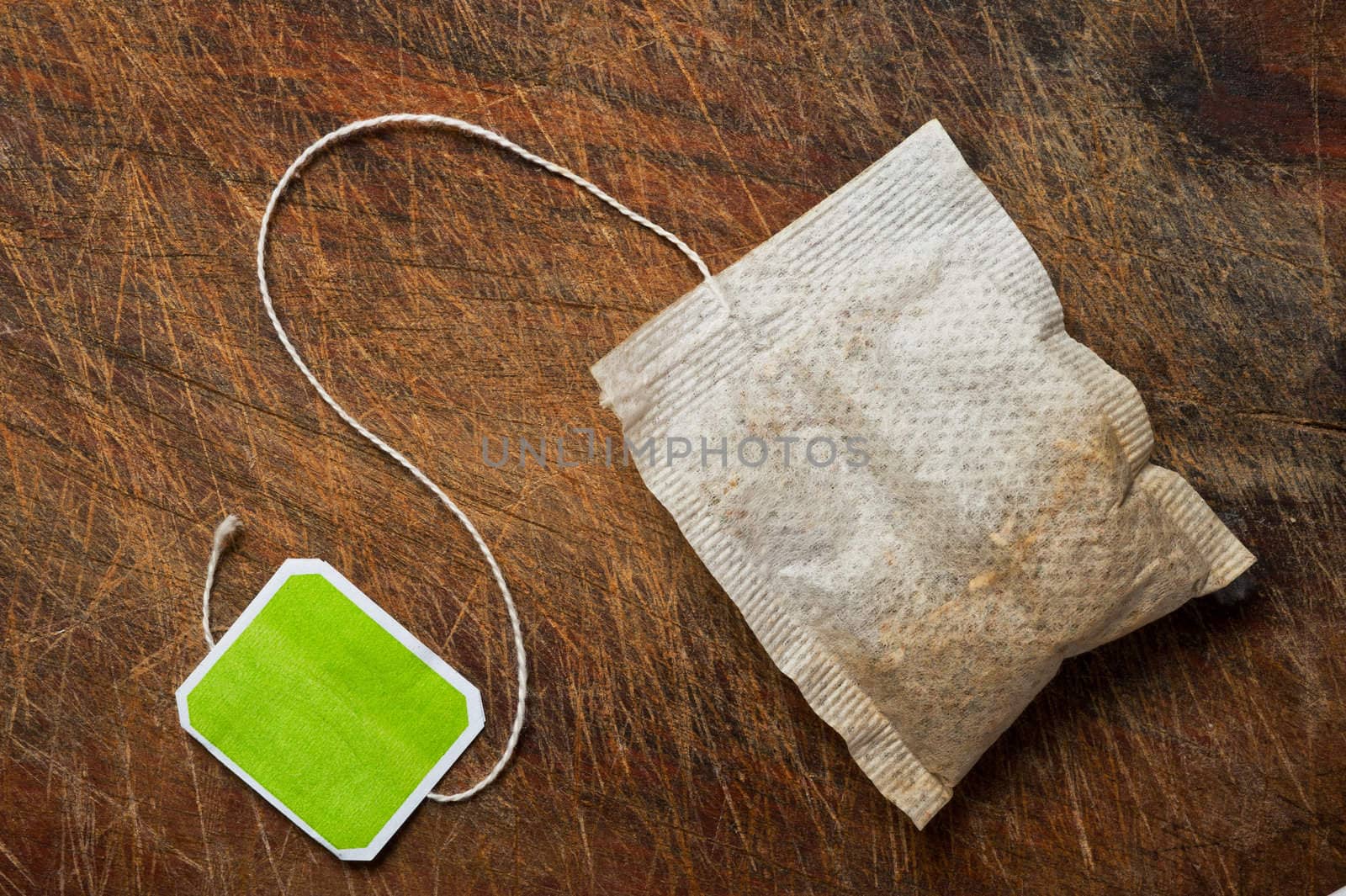 Tea bag on wooden table.