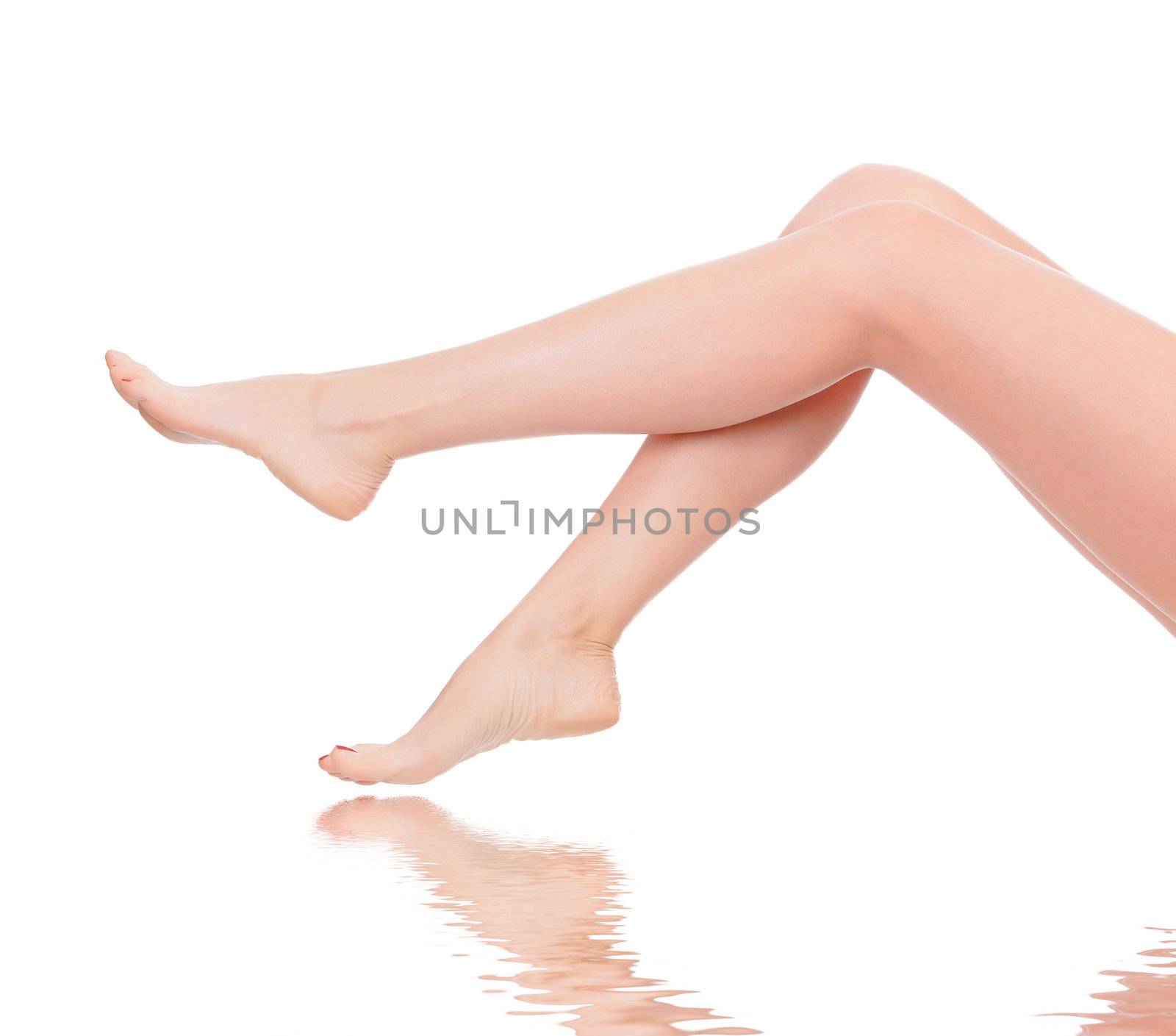 Perfect female legs with reflection on the water surface